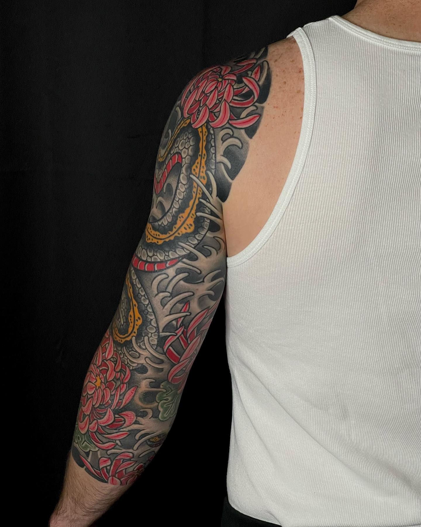 Dragon and chrysanthemum japanese irezumi tattoo on the upper arm by Mark Thompson, Dallas, Texas