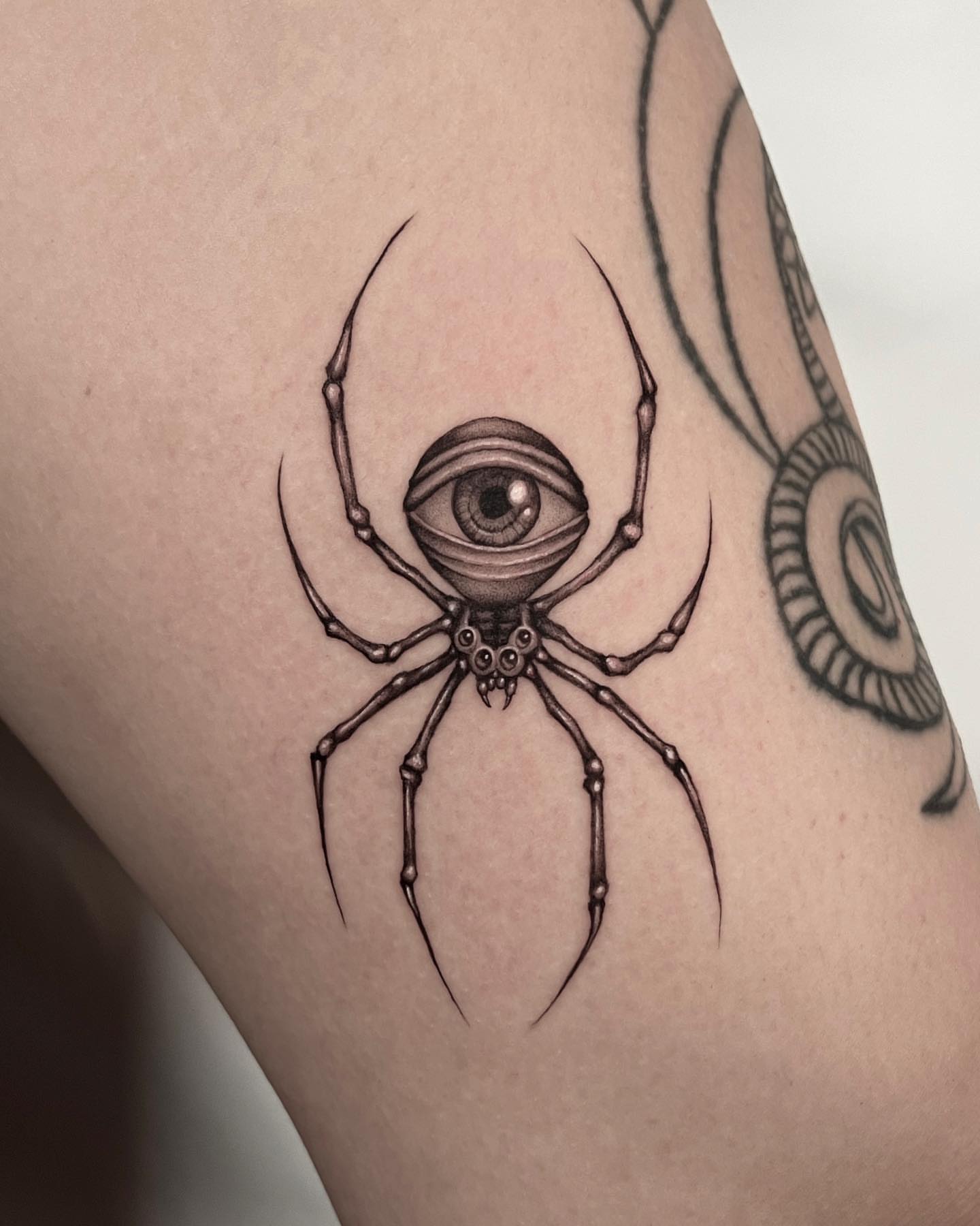 Spider with eye black and grey tattoo on the thigh by hiba ⊹ atlanta tattoo artist, Johns Creek, Georgia