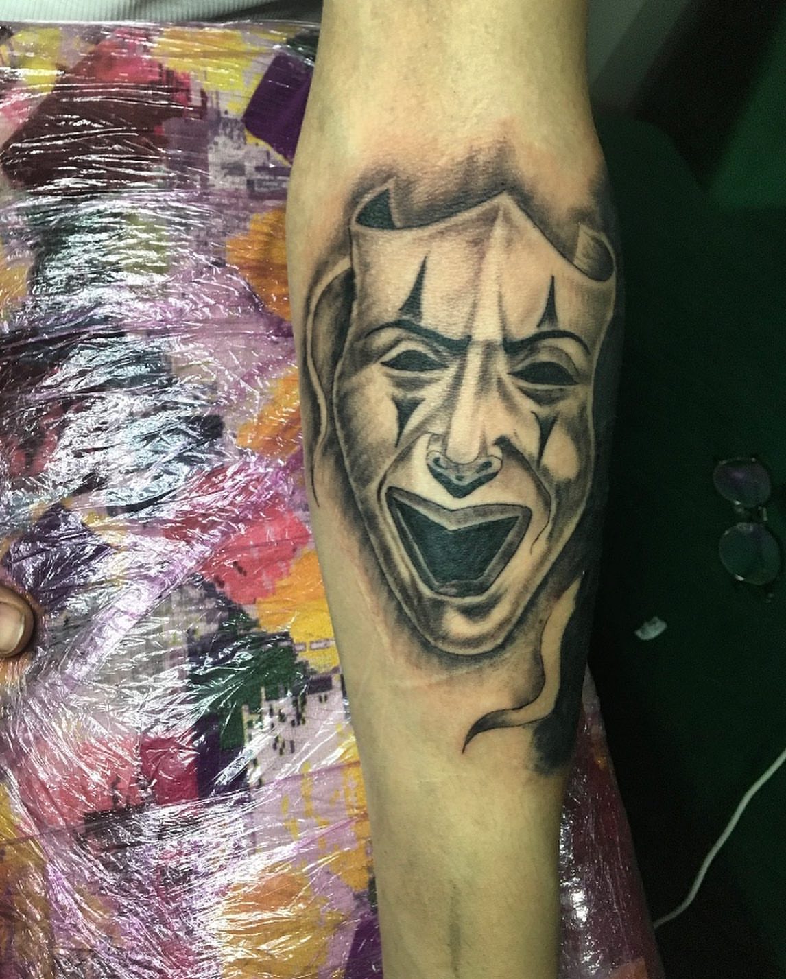 Clown face black and grey tattoo on the forearm by la flamme