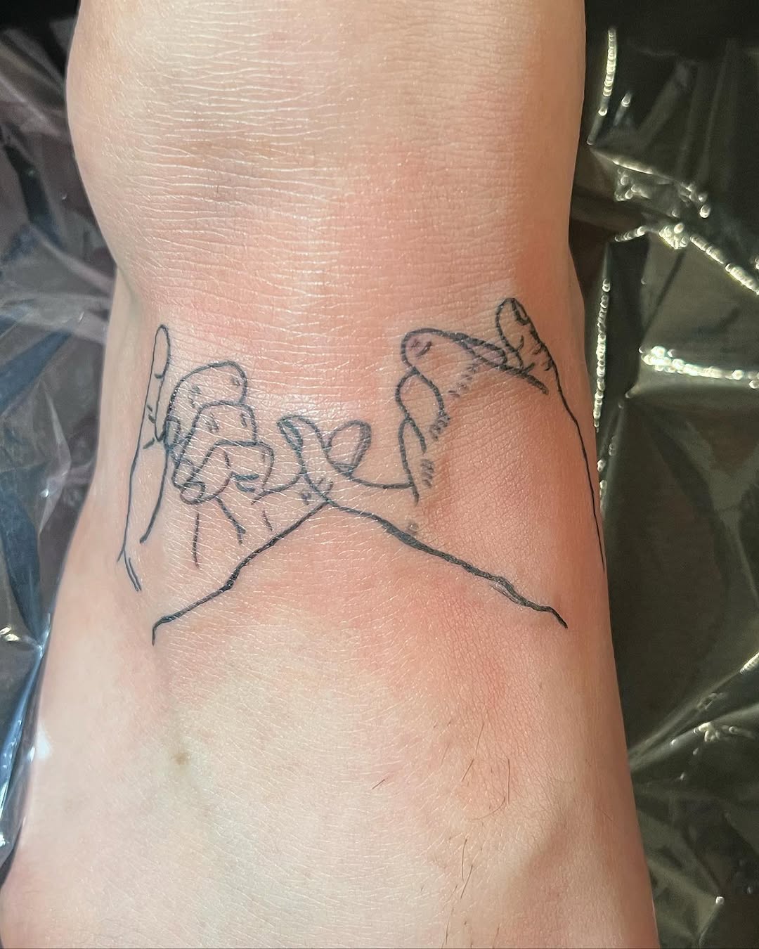 Pinky promise hands minimalist tattoo on the foot by Lea-yae’