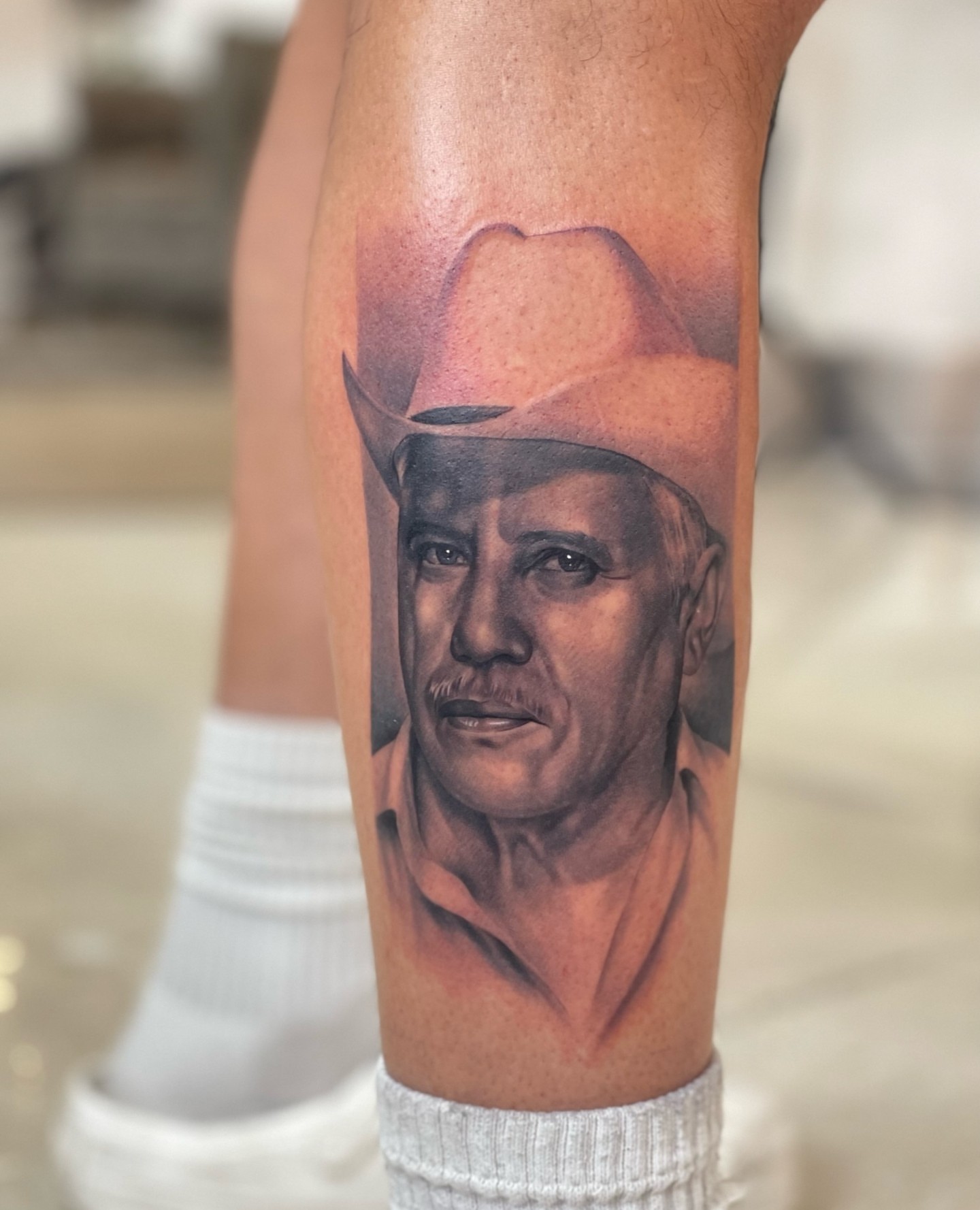 Man wearing a cowboy hat and man's face realism tattoo on the forearm by Anthony Michaels, Tucson, Arizona
