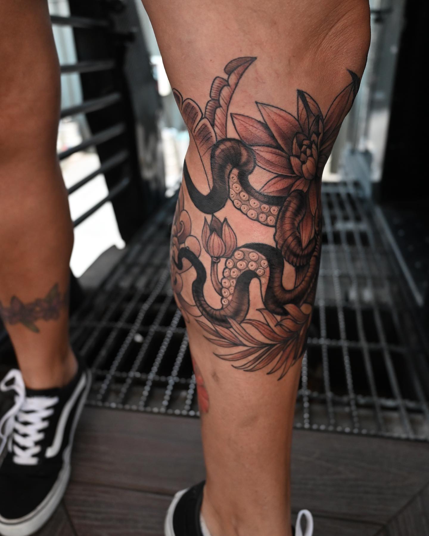 Snake and lotus realism tattoo on the calf by Neri Gersaint