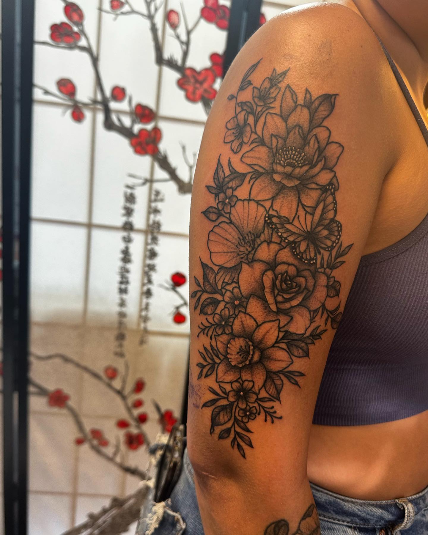 Floral bouquet dotwork tattoo on the upper arm by Kassie Perian