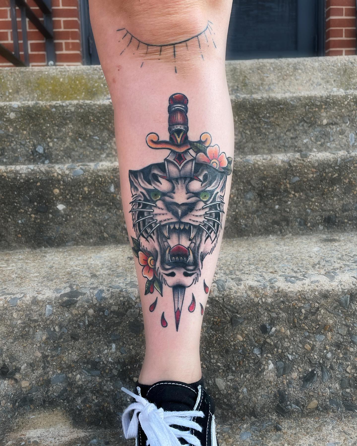 Tiger head with dagger American traditional tattoo on the calf by Brookelyn