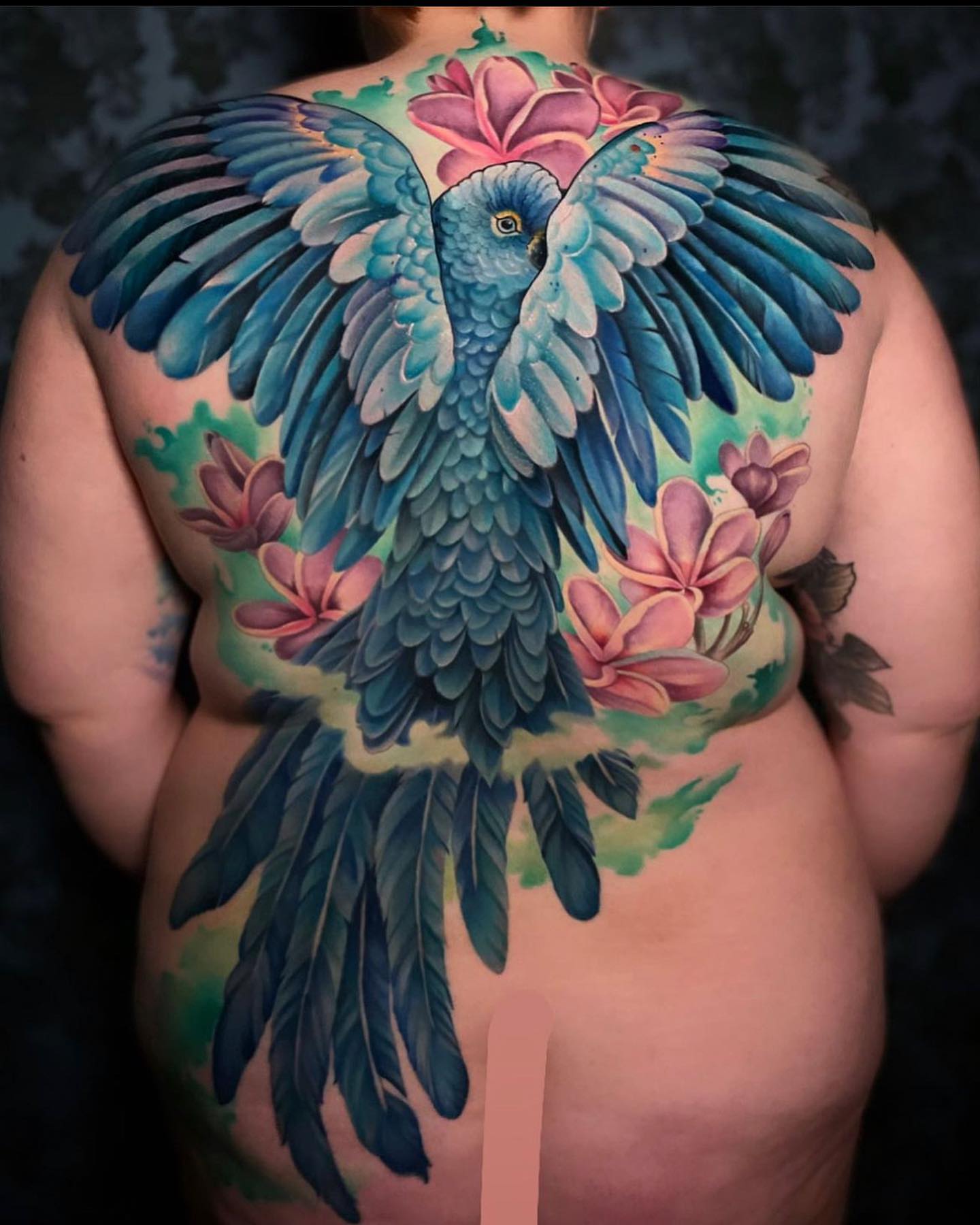 Parrot and flowers realism tattoo on the back by Melis Fusco