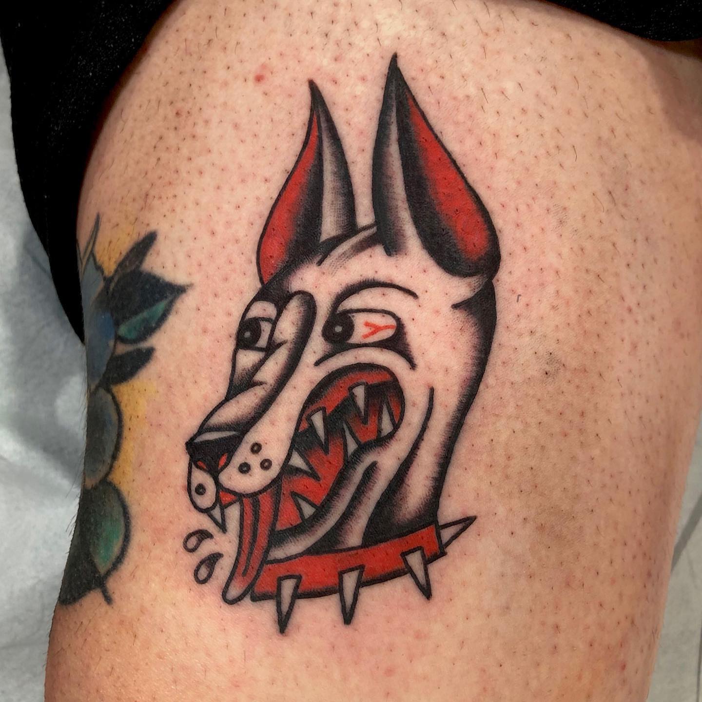 Angry dog head American traditional tattoo on the thigh by brenden