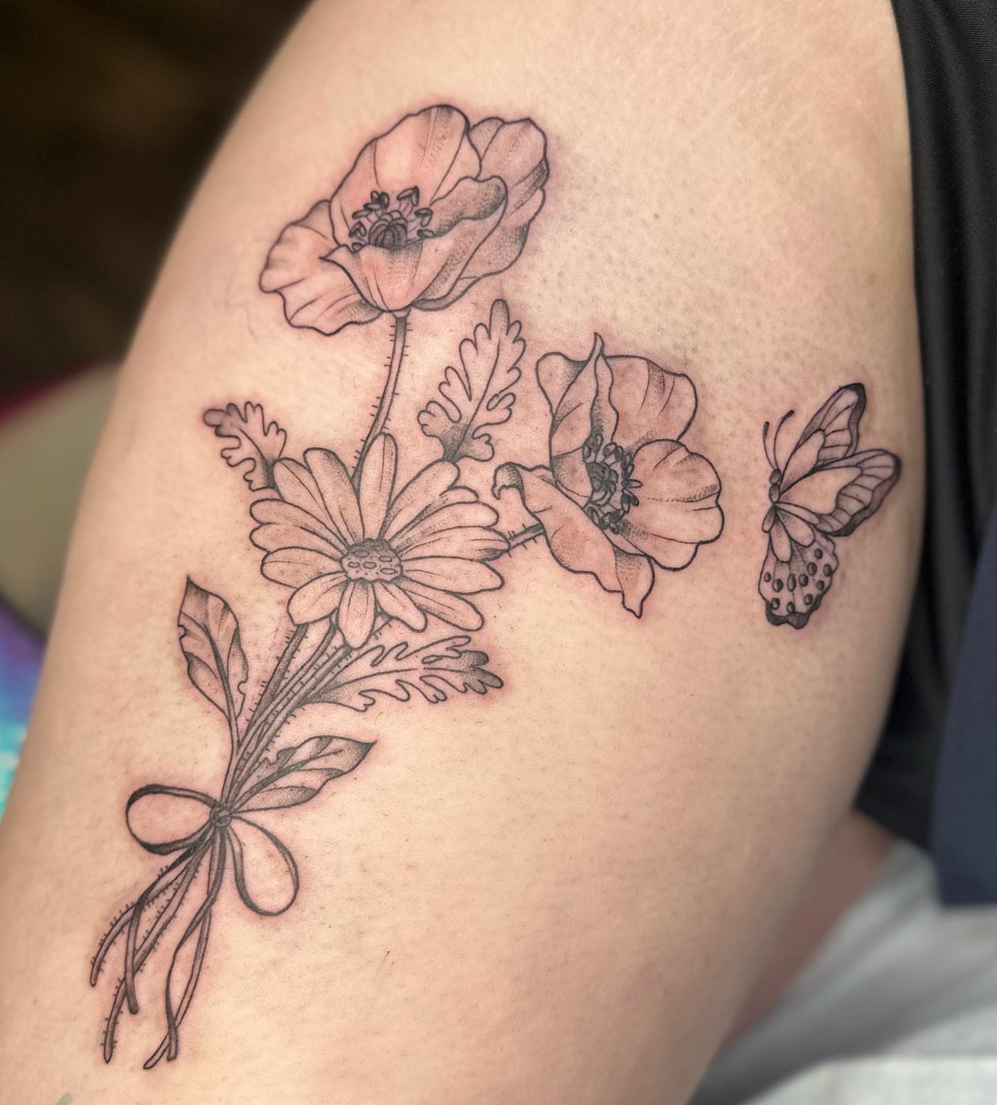 Flowers and butterfly black and grey tattoo on the shoulder by Halle Haas