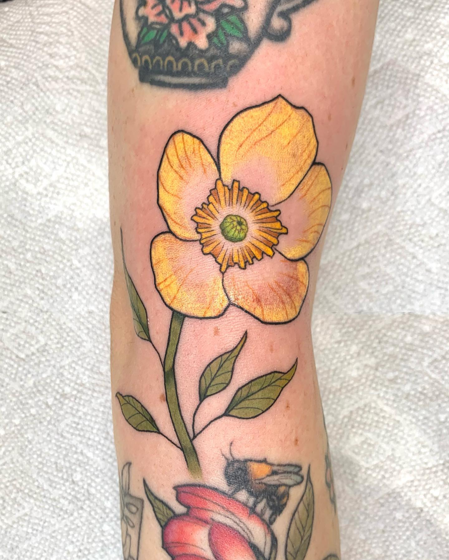 Yellow flower realism tattoo on the forearm by Mike G.