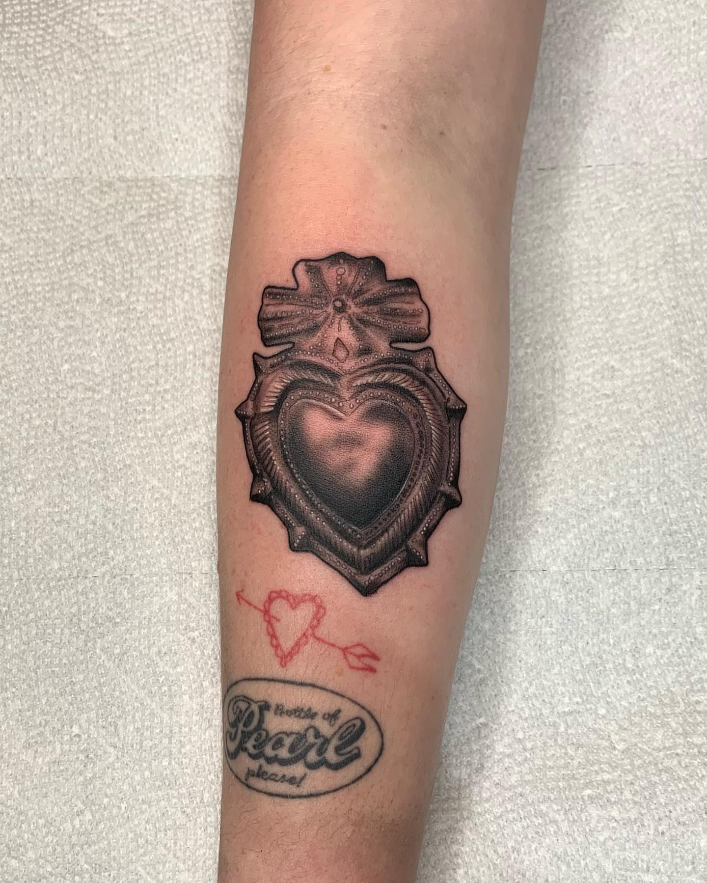 Heart with cross black and grey tattoo on the forearm by Mike G.