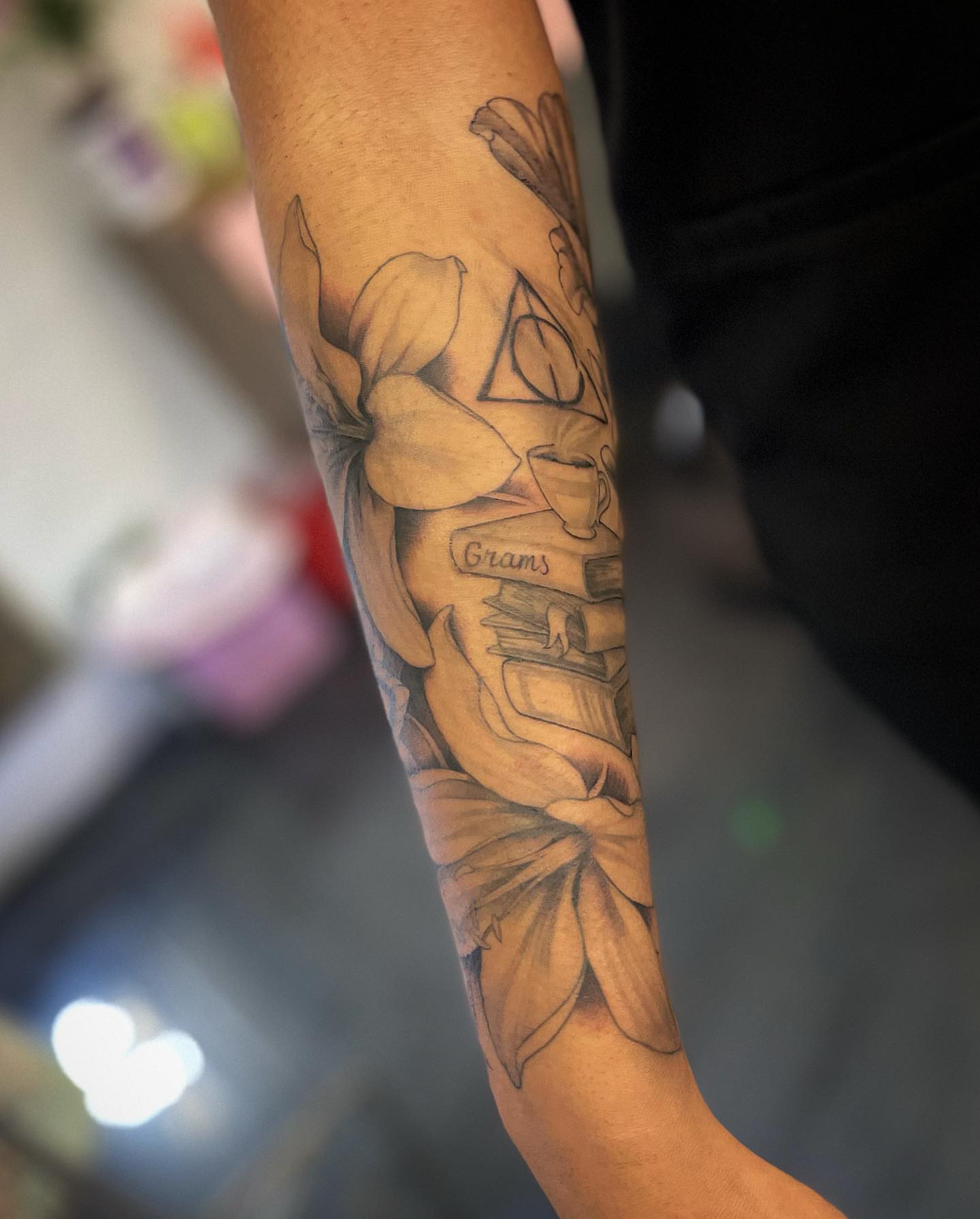 Flower and books black and grey tattoo on the forearm by π‘πΆπΈπ½ππ ππΎππππ