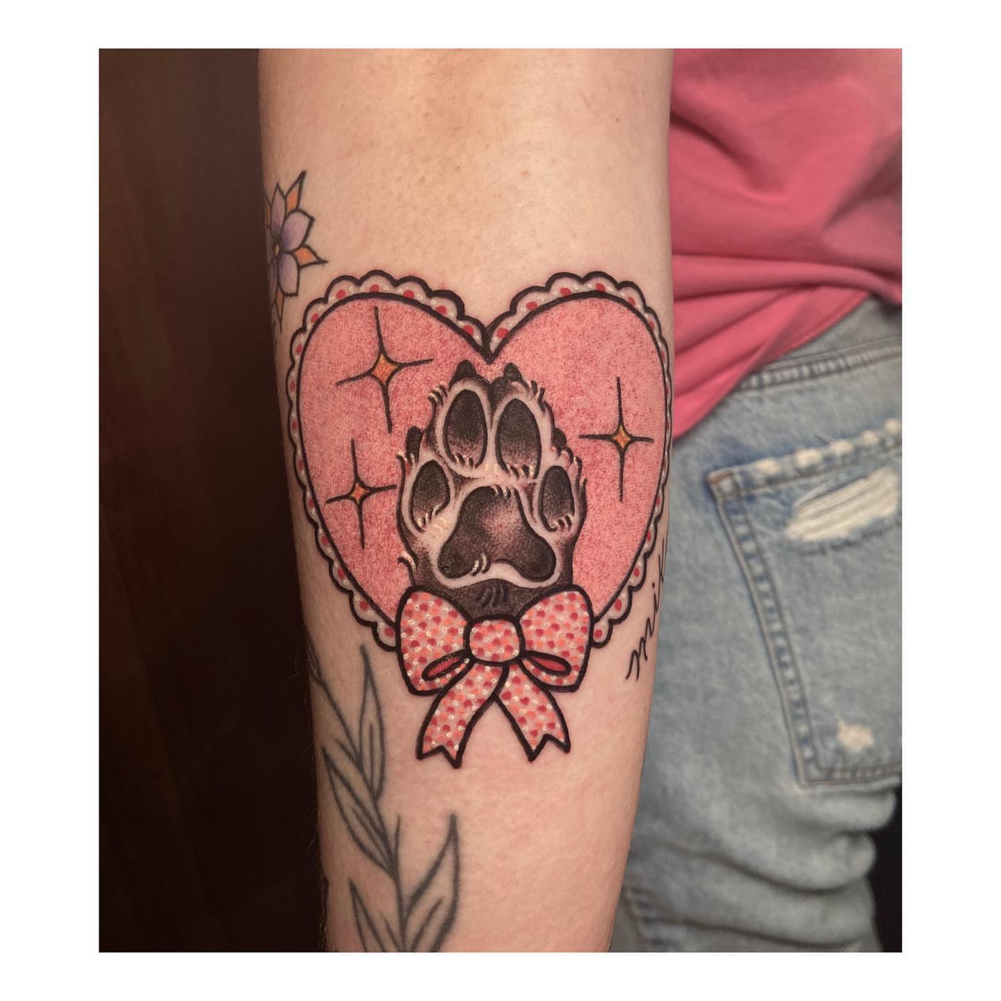 Paw print in heart American traditional tattoo on the forearm by Luna