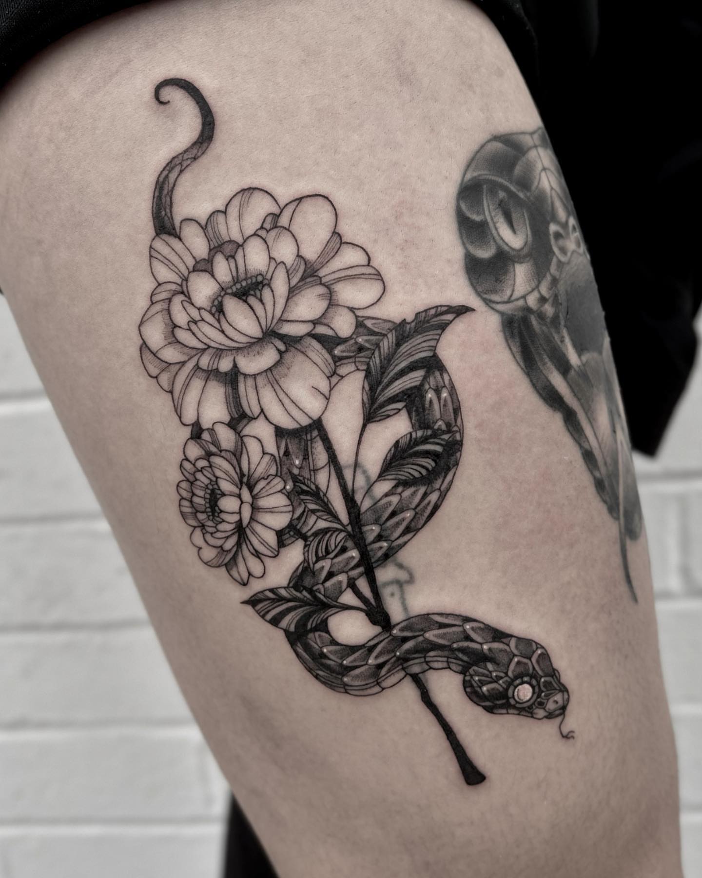 Snake and flowers realism tattoo on the thigh by Melanie