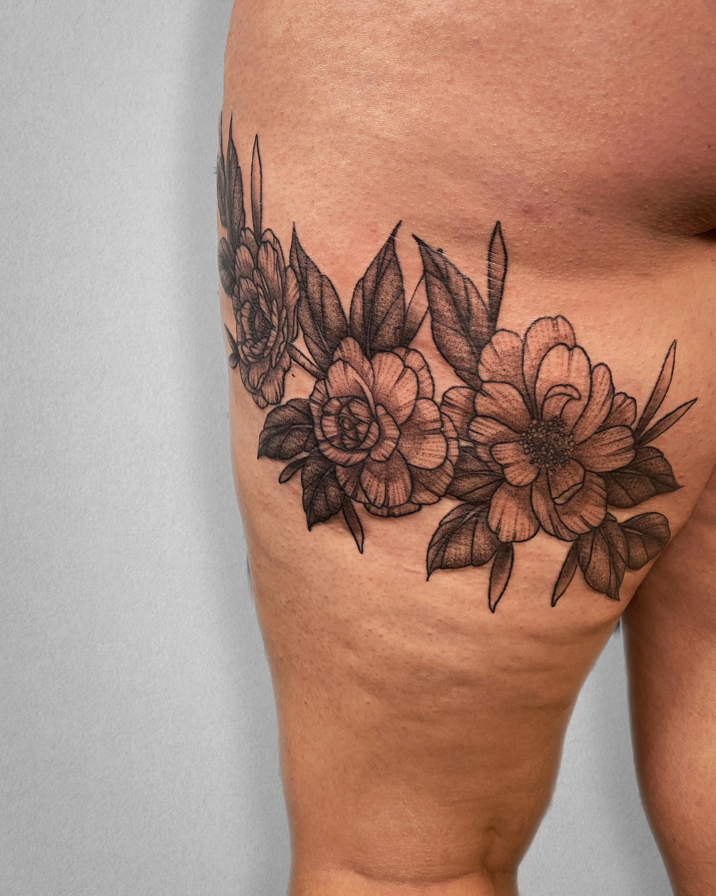 Floral arrangement black and grey tattoo on the thigh by Mallory Miller π³οΈβπ Eugene