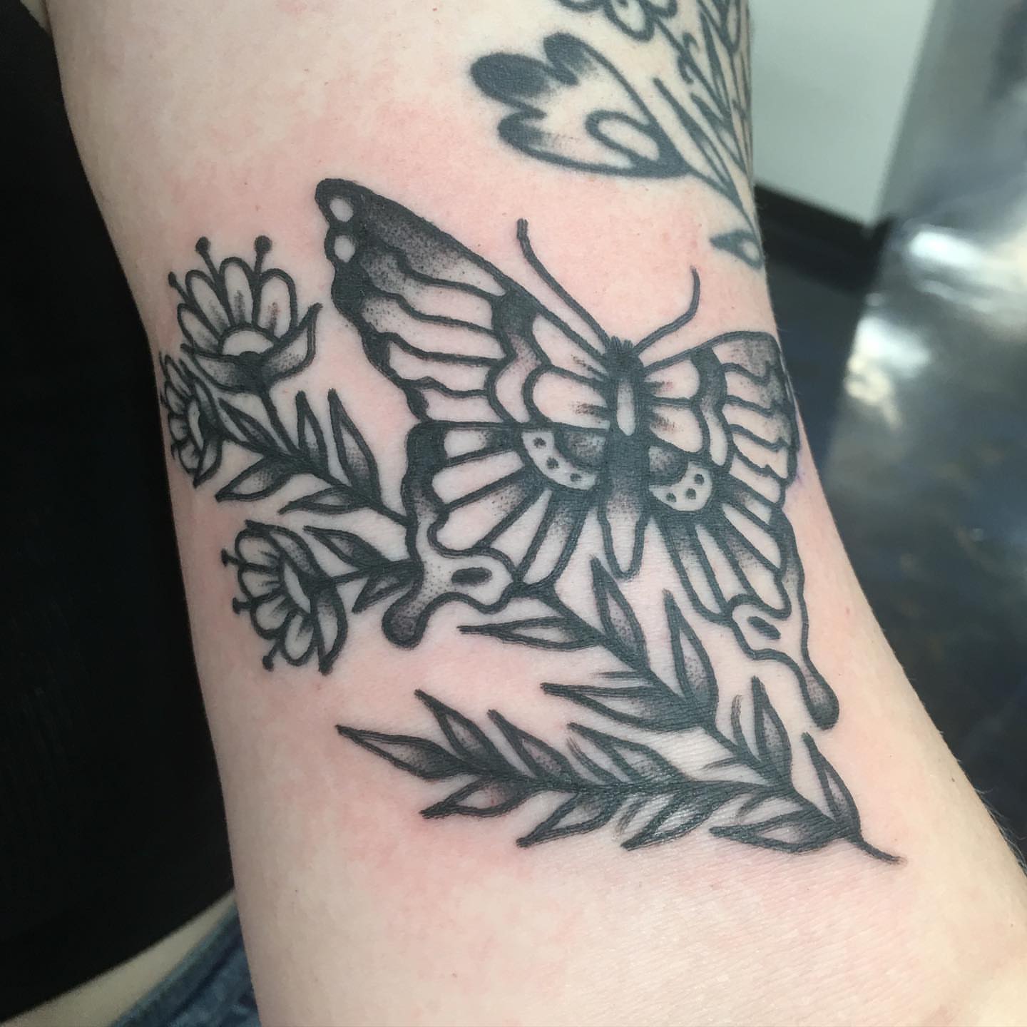 Butterfly and flowers black and grey tattoo on the forearm by Abbey Martin, Nashville, Tennessee