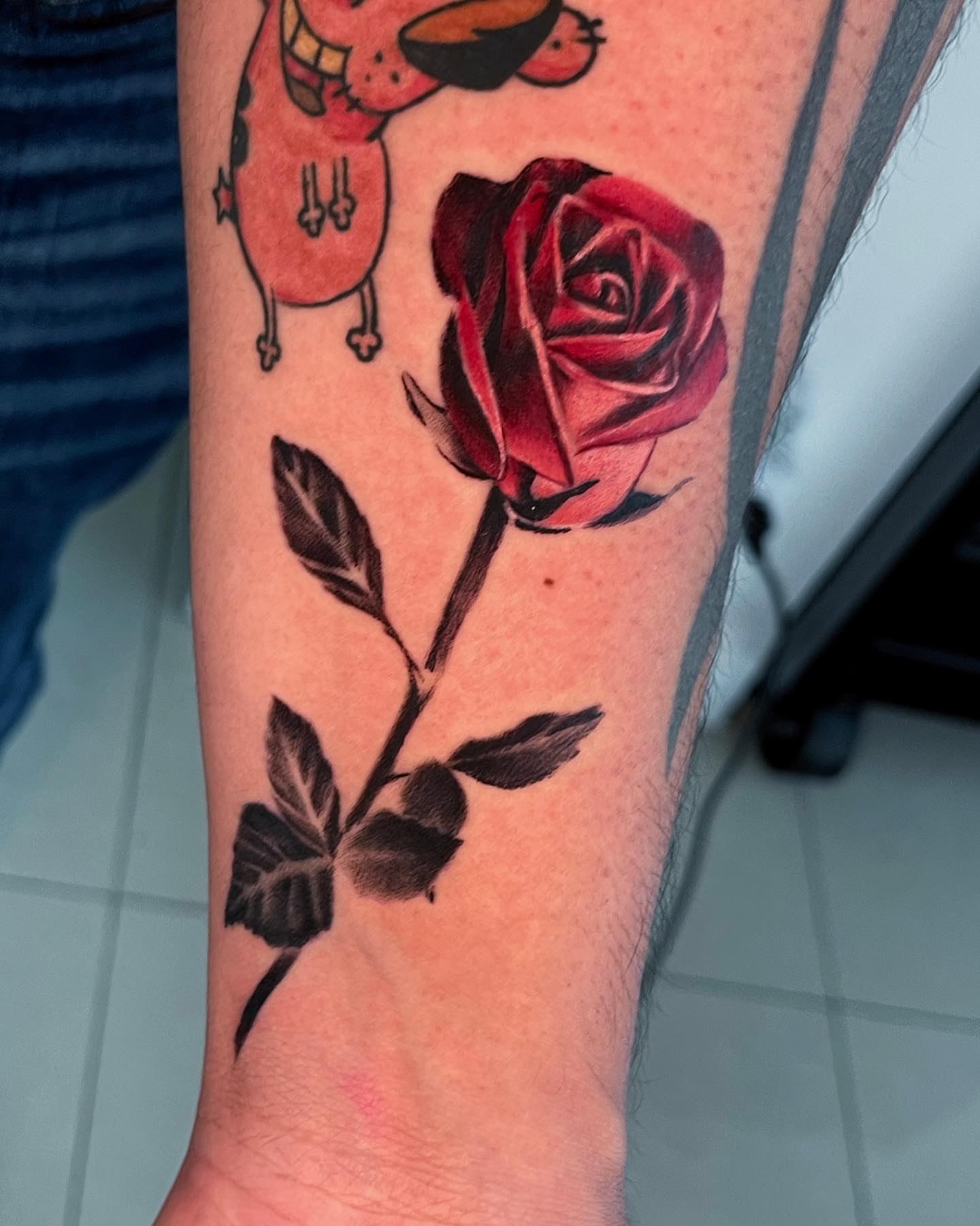 Red rose realism tattoo on the forearm by Tattoo Artist