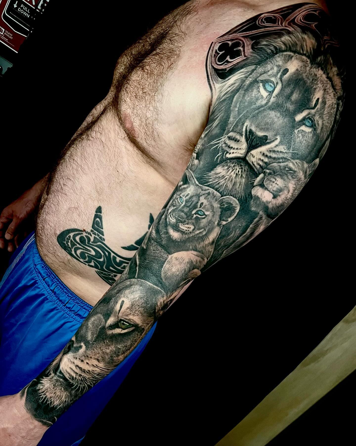 Lion family realism tattoo on the upper arm by Vinny Holistic Ink