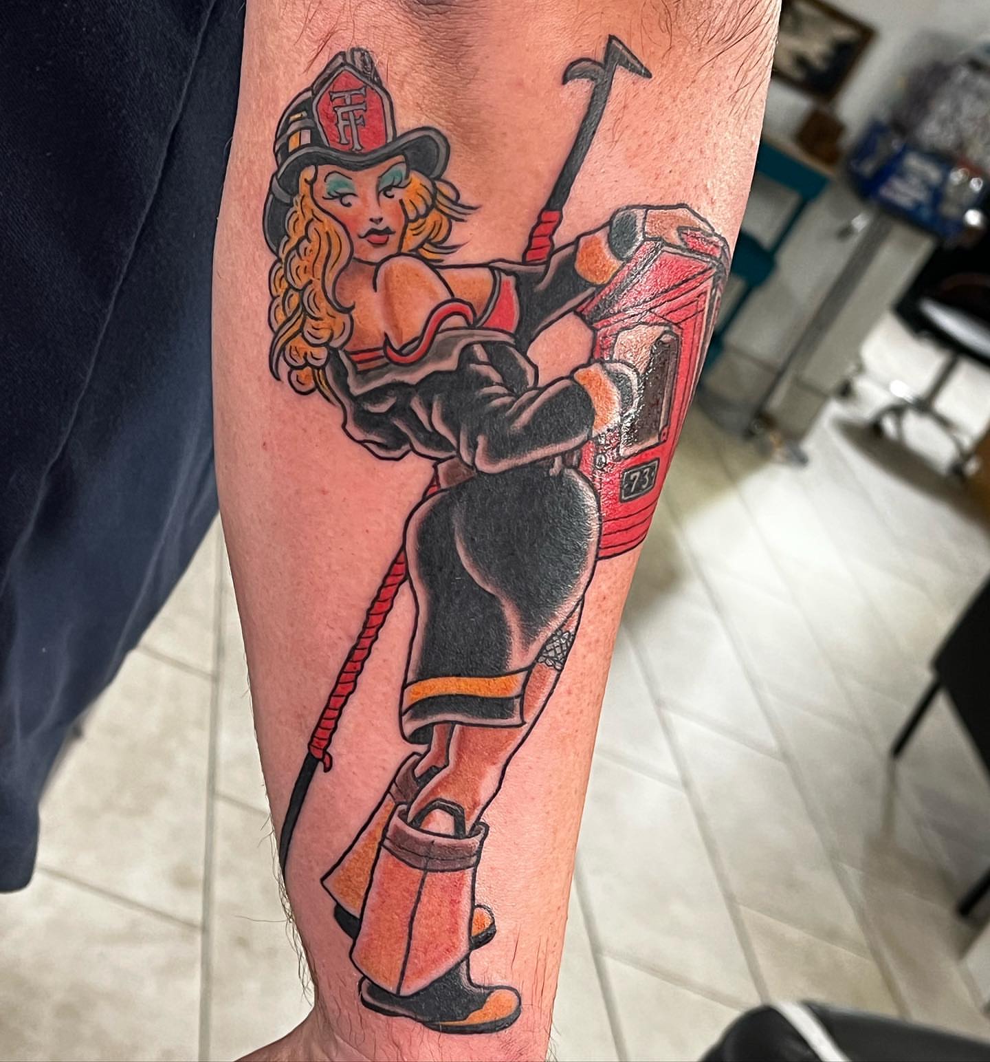 Firefighter pin-up American traditional tattoo on the forearm by Levi Cox, Powell, Ohio