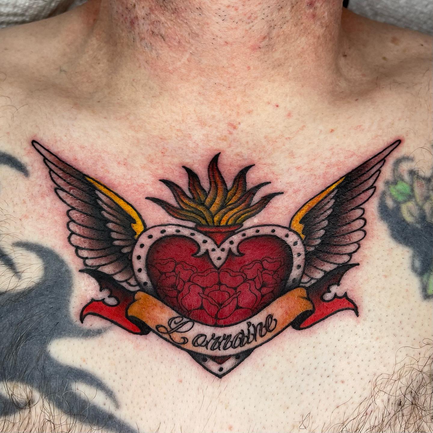 Heart with wings American traditional tattoo on the chest by Lexx Christine