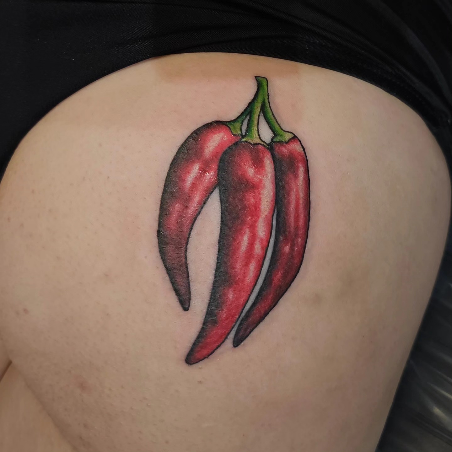 Chili peppers realism tattoo on the thigh by Gabrielle Nicole Soucie