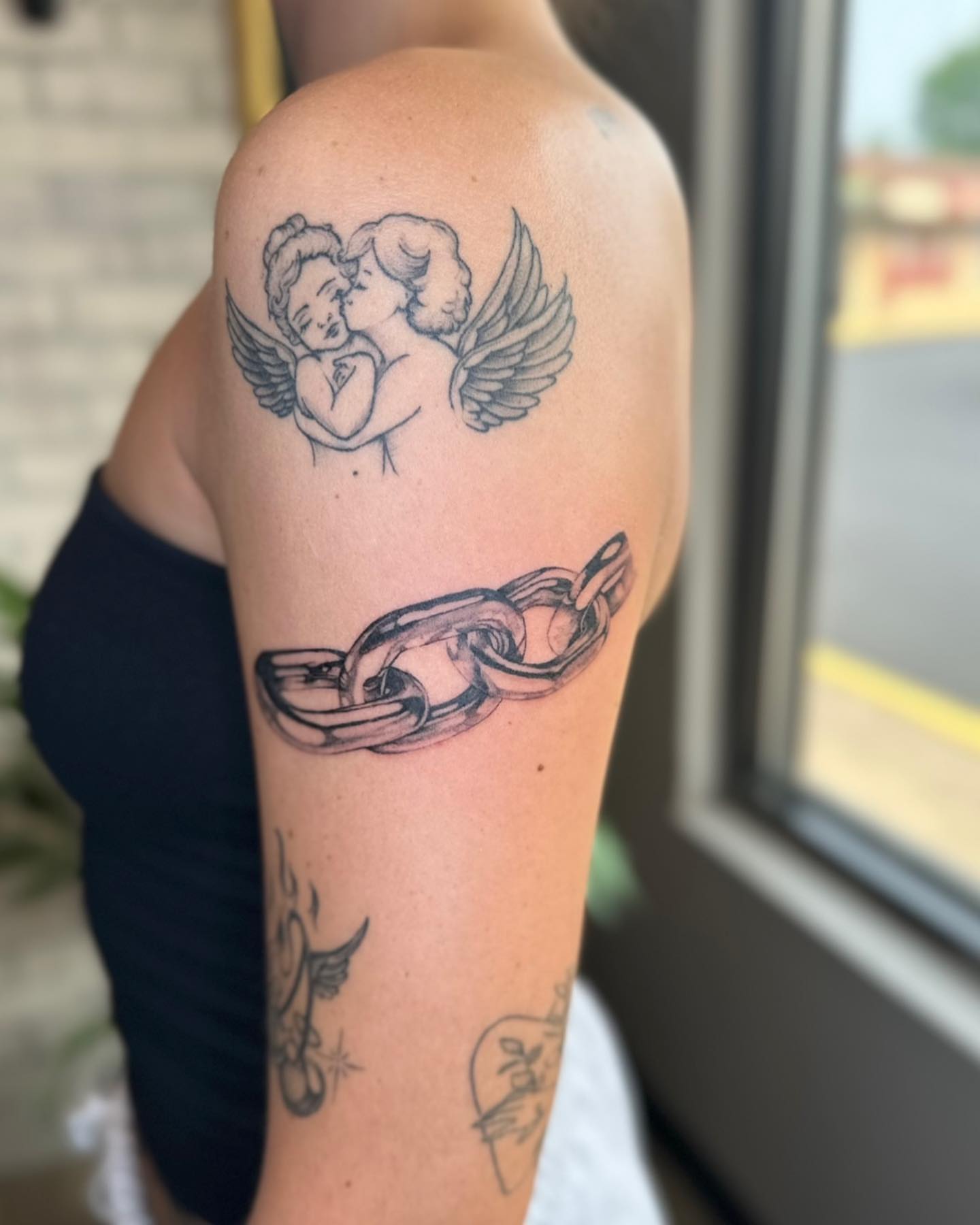 Angels and chain black and grey tattoo on the upper arm by Steph ❤️‍🔥 New Jersey Tattoo Artist