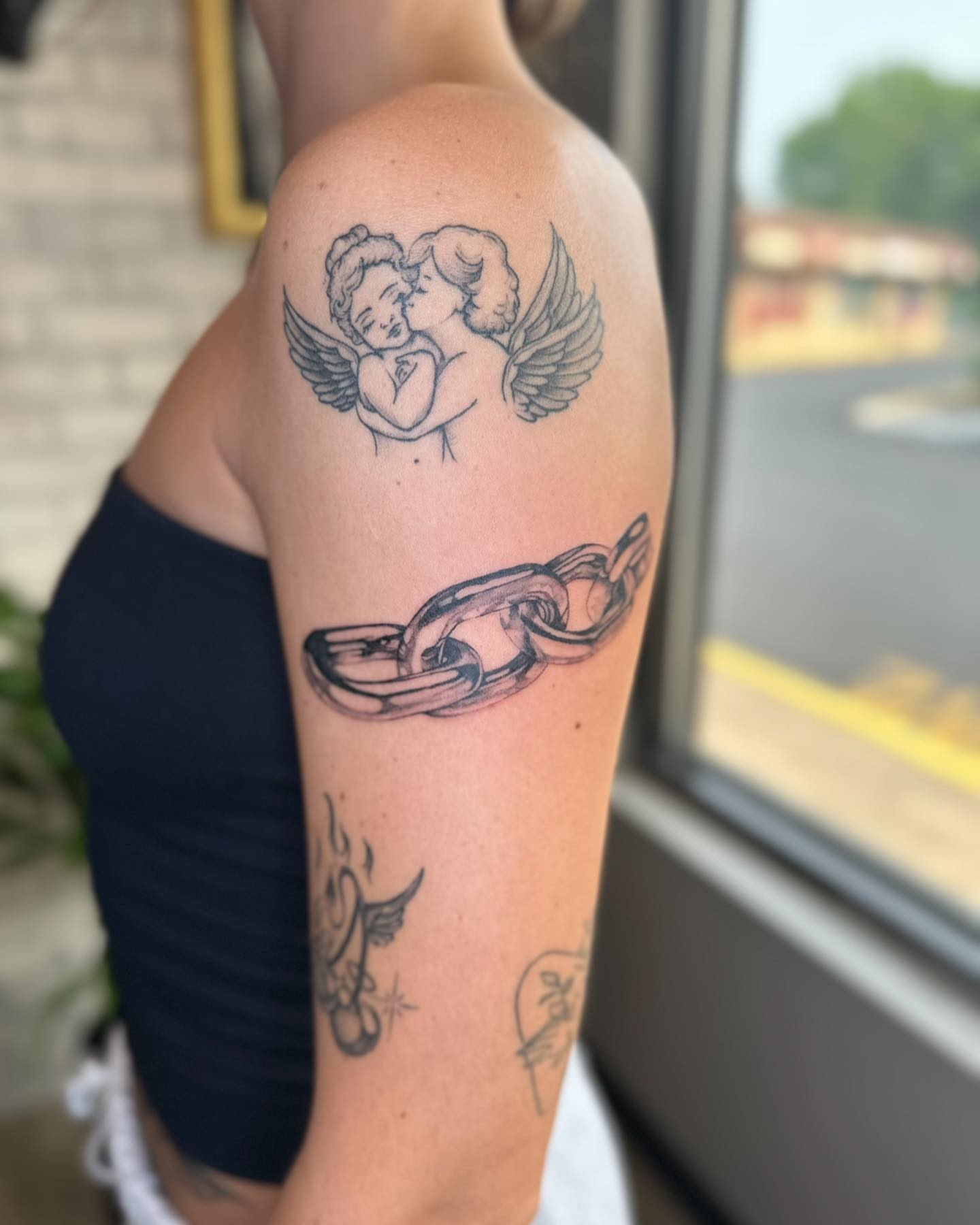 Angels and chain black and grey tattoo on the upper arm by Steph ❤️‍🔥 New Jersey Tattoo Artist