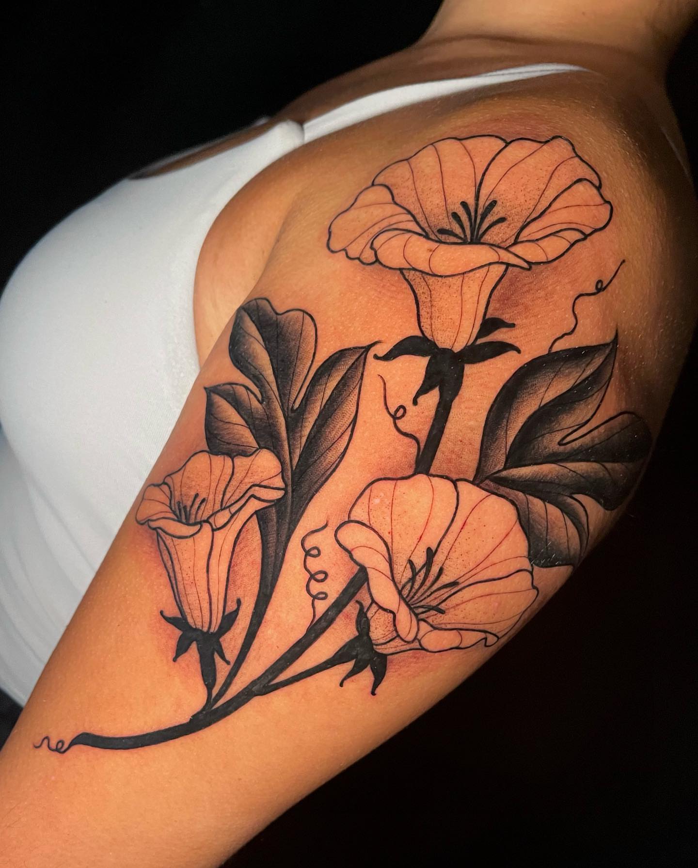 Morning glory flowers black and grey tattoo on the upper arm by Amber