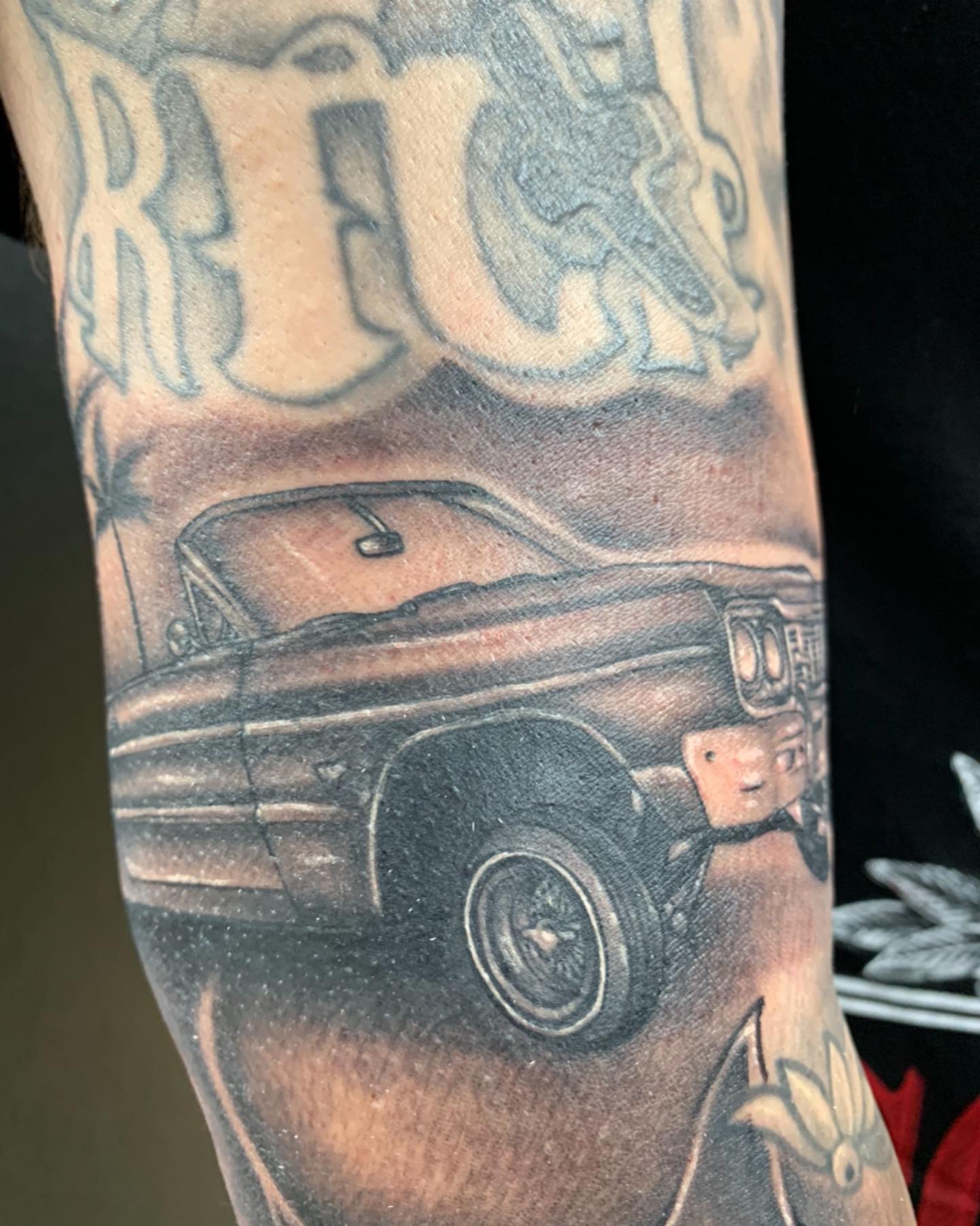Car black and grey tattoo on the forearm by Tattoos By Chico