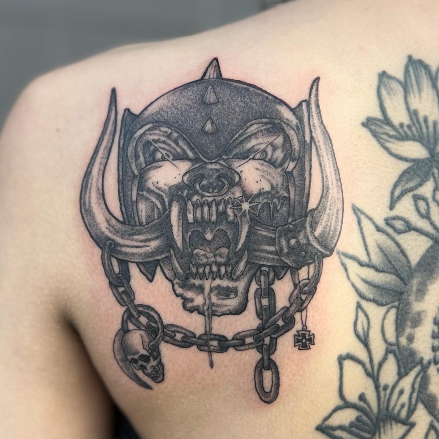 Demon skull with chains dark realism tattoo on the shoulder by Kyle Black