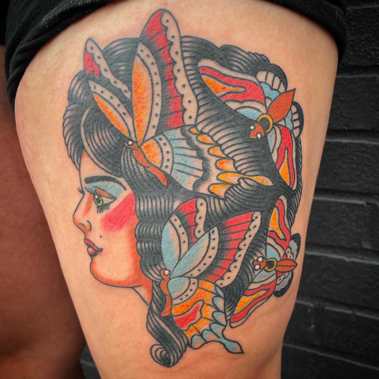 Woman with butterflies American traditional tattoo on the thigh by Timothy Wood