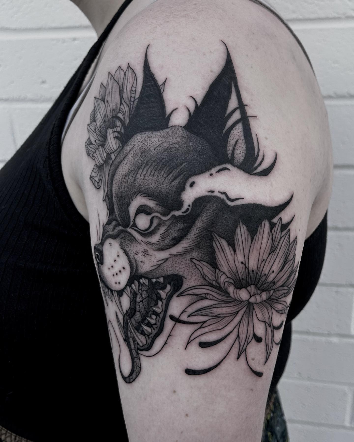 Dog and flower dotwork tattoo on the shoulder by Melanie