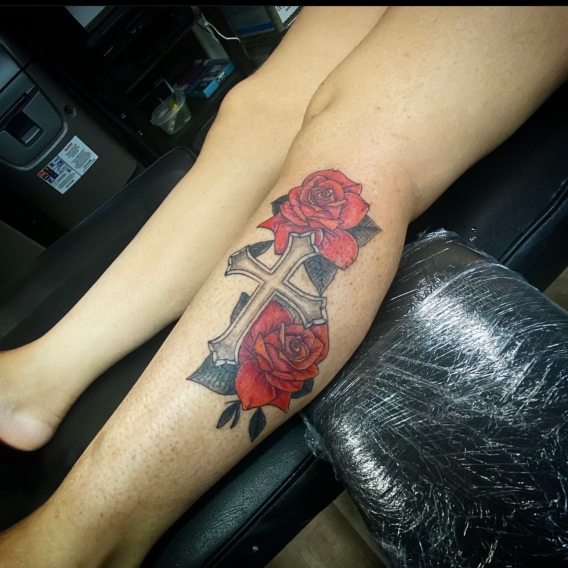 Cross and roses American traditional tattoo on the forearm by Erasmo Vasquez