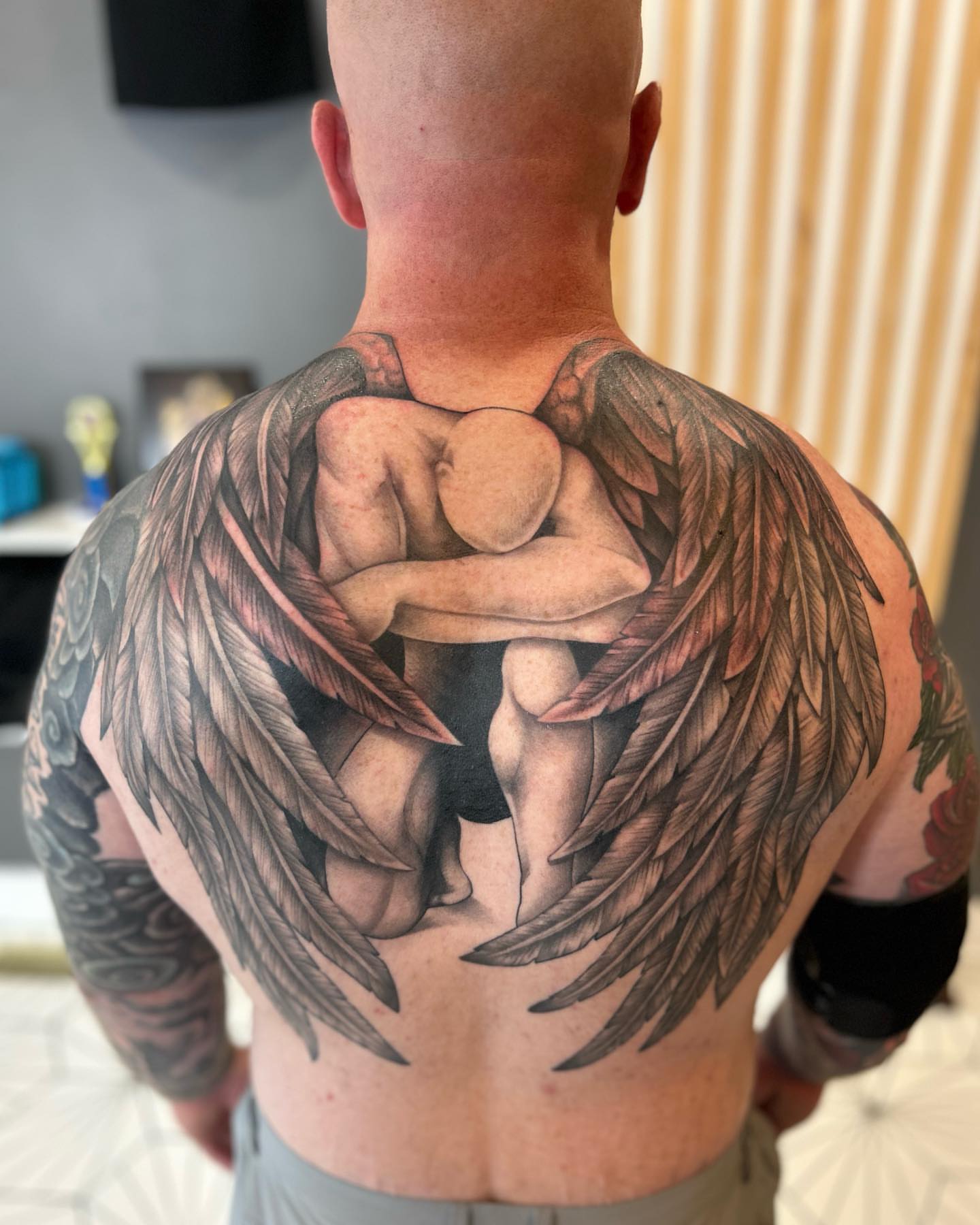 Couple embracing realism tattoo on the back by Taylor Steckman