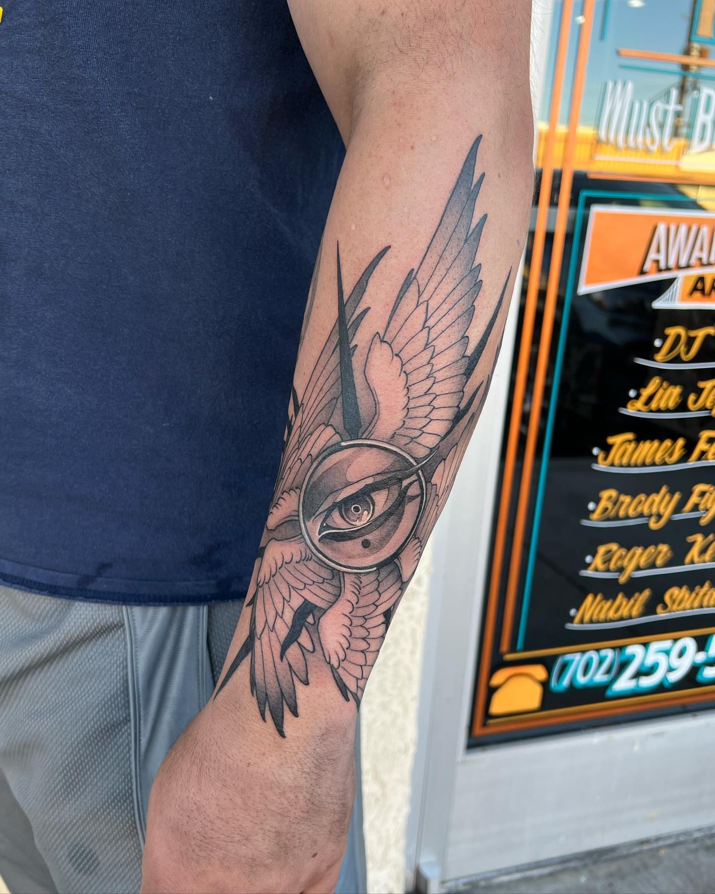 Eye with wings black and grey tattoo on the forearm by Neo-Traditional tattoos in Las Vegas