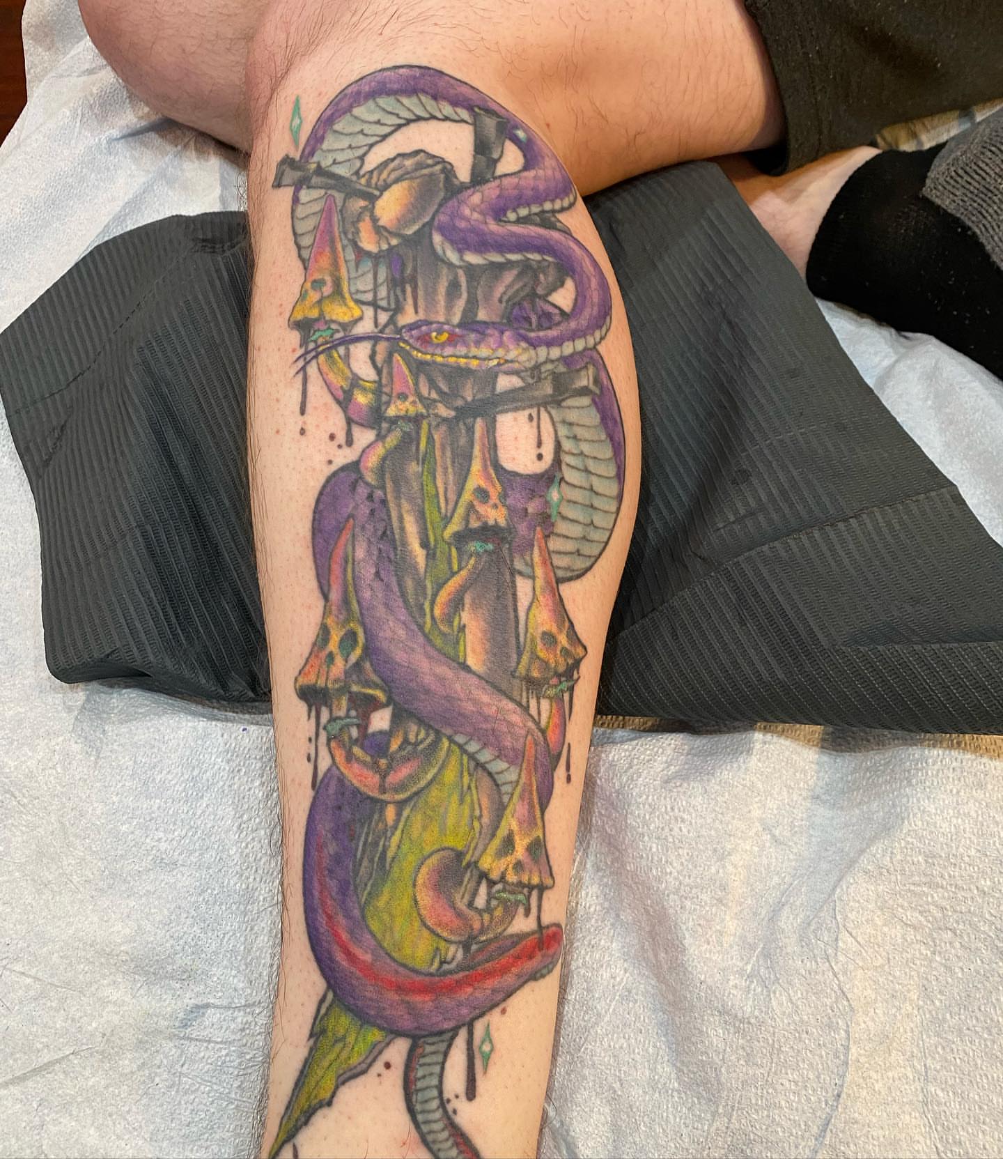 Serpent and skull new school tattoo on the forearm by Christopher Sanders