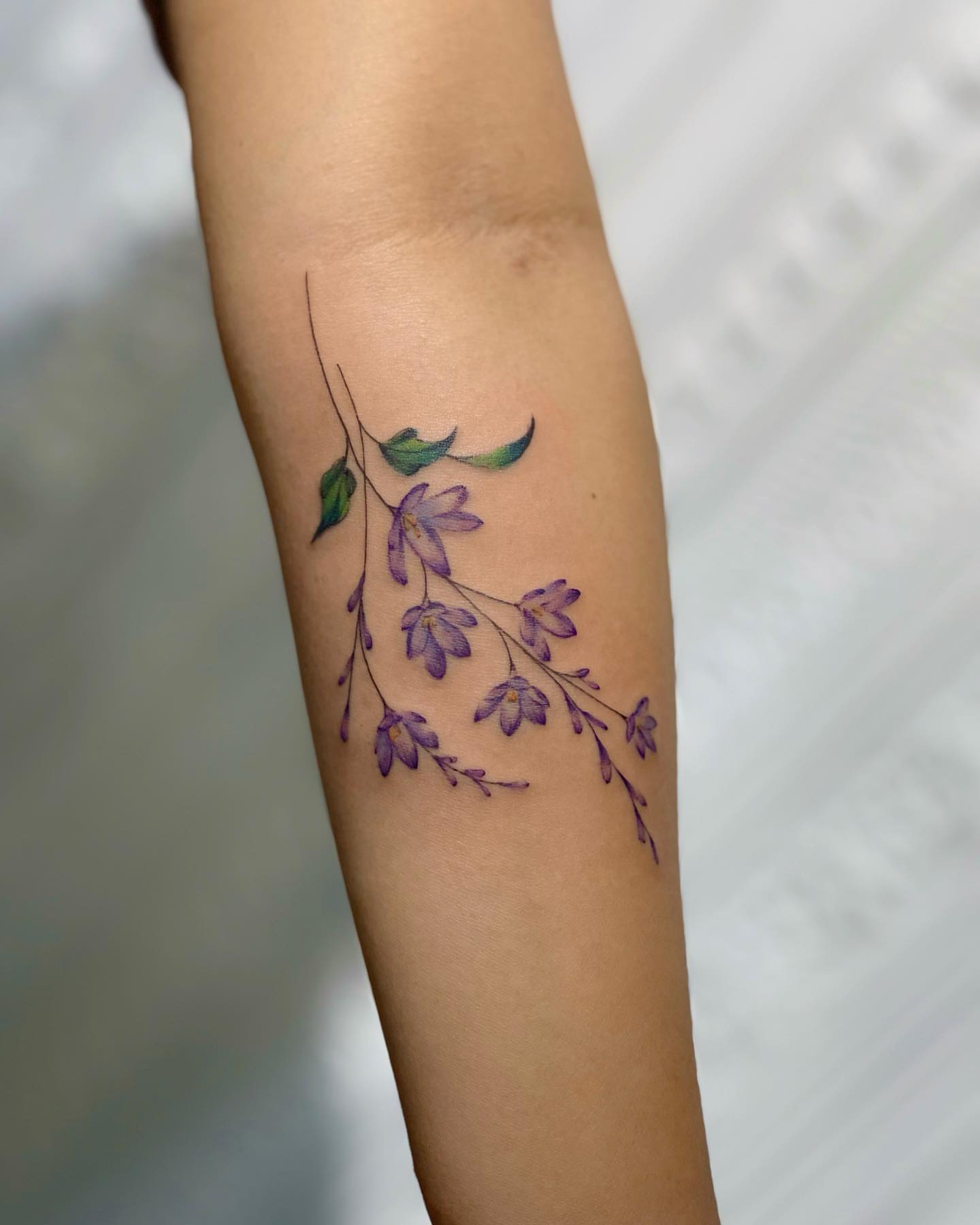 Purple flowers watercolor tattoo on the forearm by Seattle Tattoo Artist PingPing, Seattle, Washington
