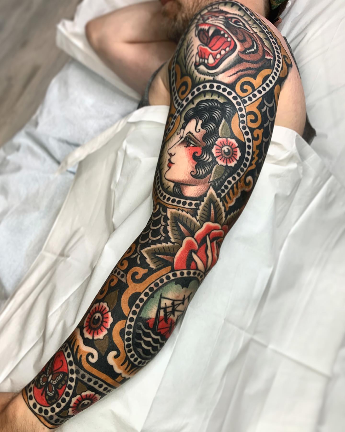 Woman with tiger American traditional tattoo on the forearm by Wes Hoffman
