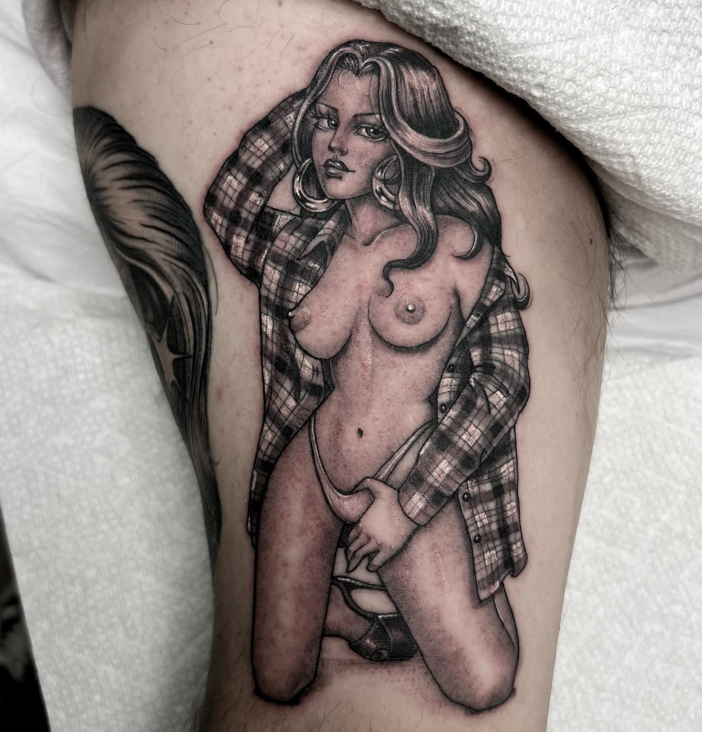 Woman in plaid shirt black and grey tattoo on the thigh by Valerie Dominguez