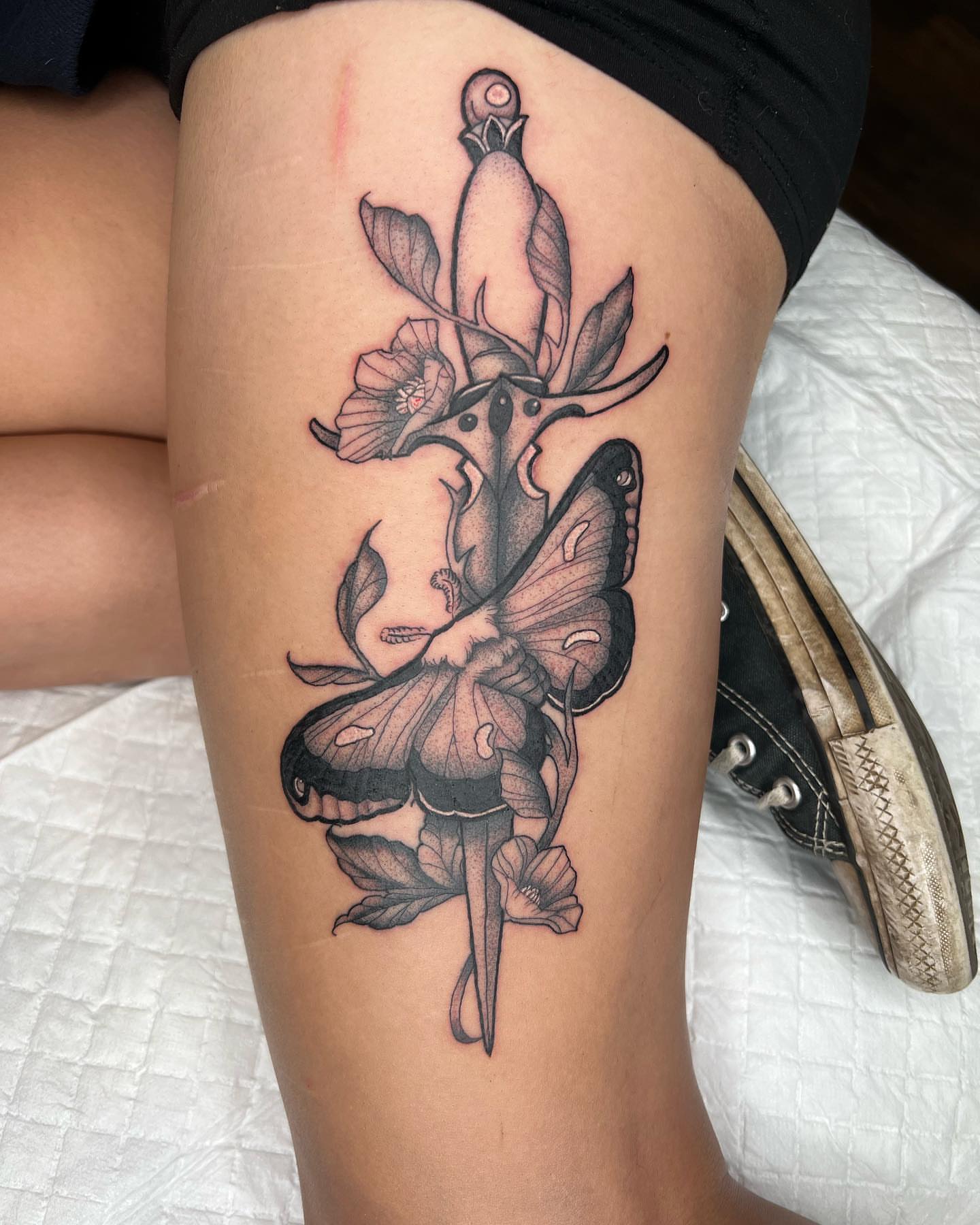 Butterfly and flower realism tattoo on the thigh by Kayla Cordova