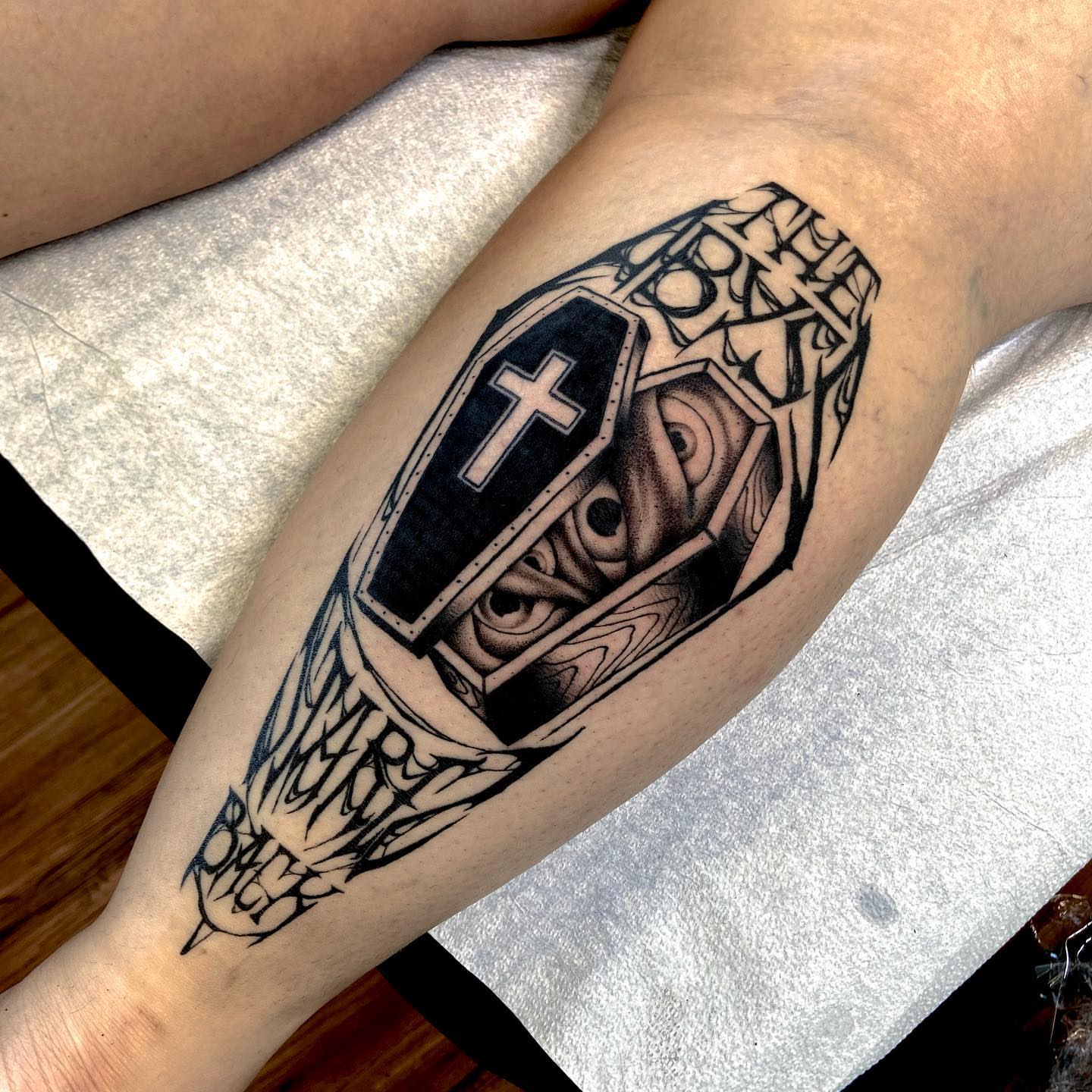 Coffin with cross black and grey tattoo on the forearm by Nathan