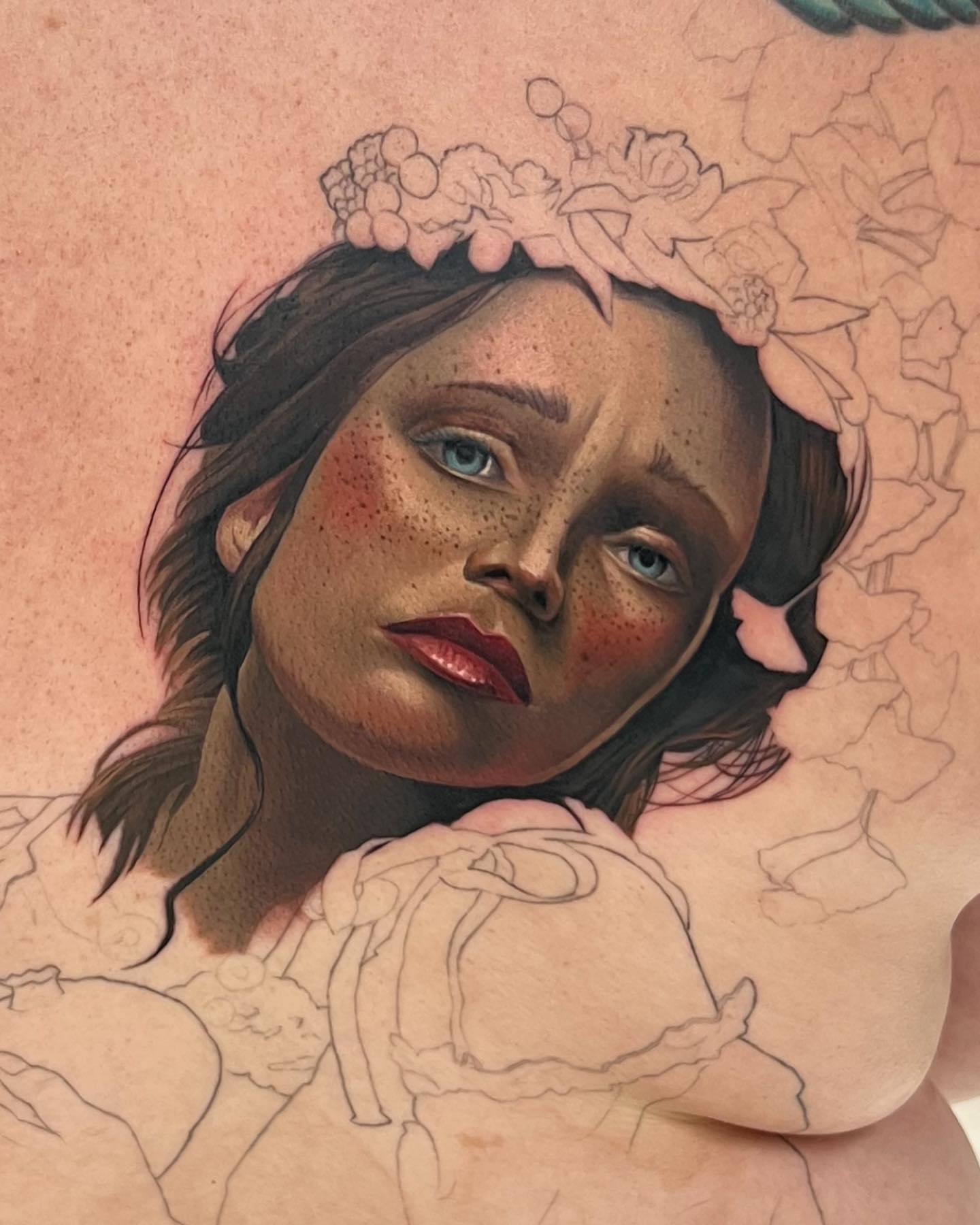 Woman with floral crown realism tattoo on the chest by Derek Gardner