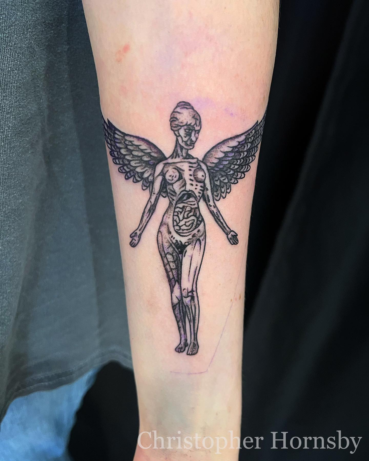 Anatomical angel black and grey tattoo on the forearm by Chris Hornsby