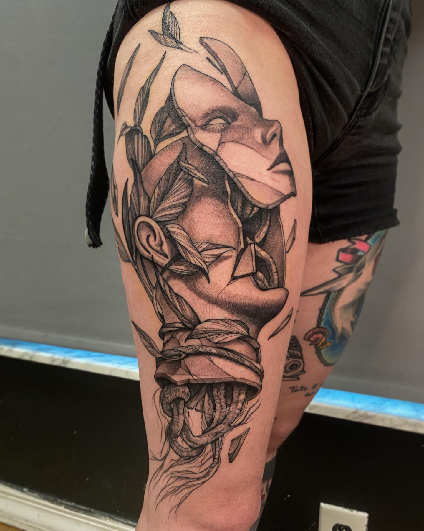 Mask with leaves geometric tattoo on the forearm by Tattoo Artist