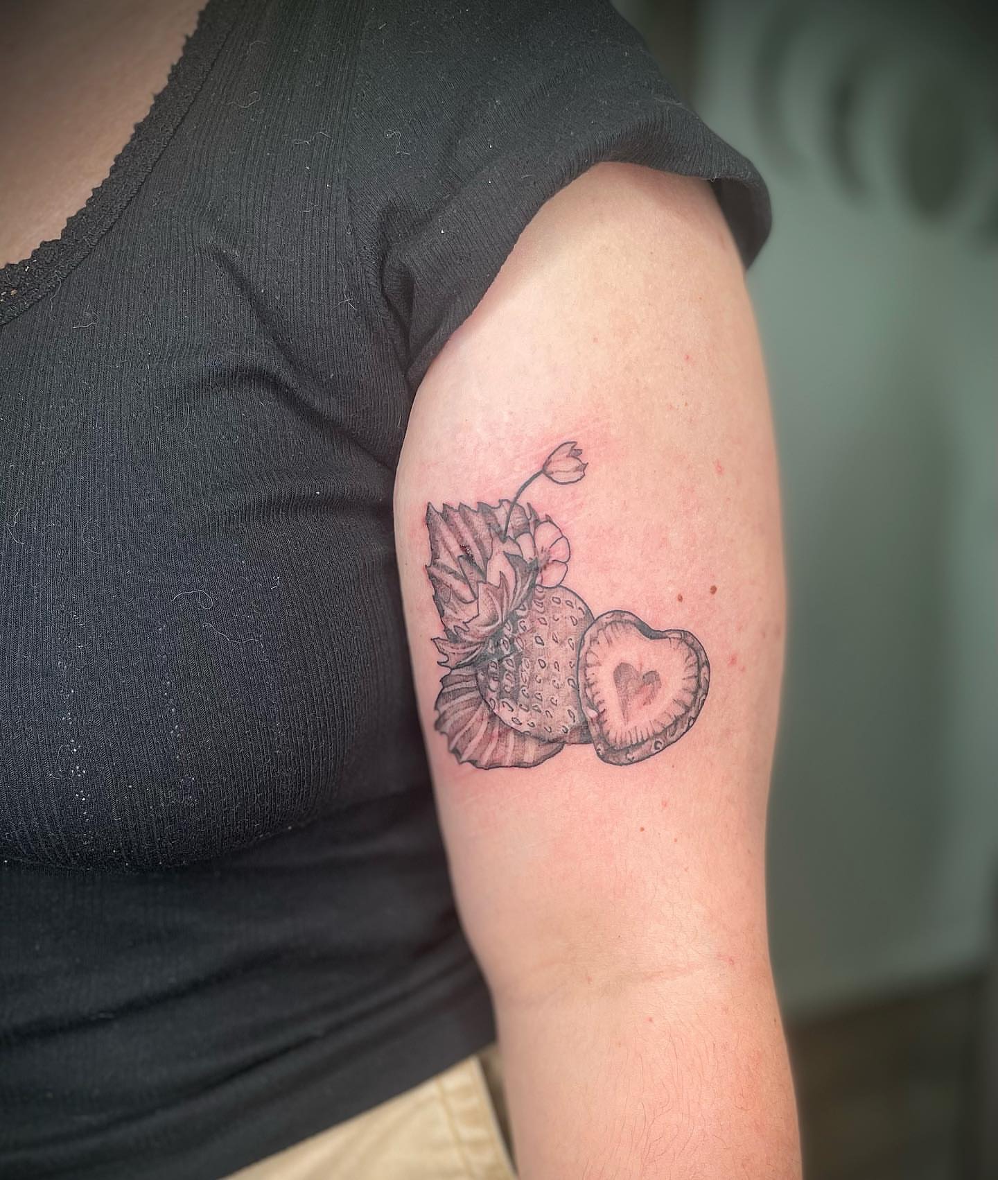 Pineapple and heart black and grey tattoo on the upper arm by Harley Lane ๐ซ