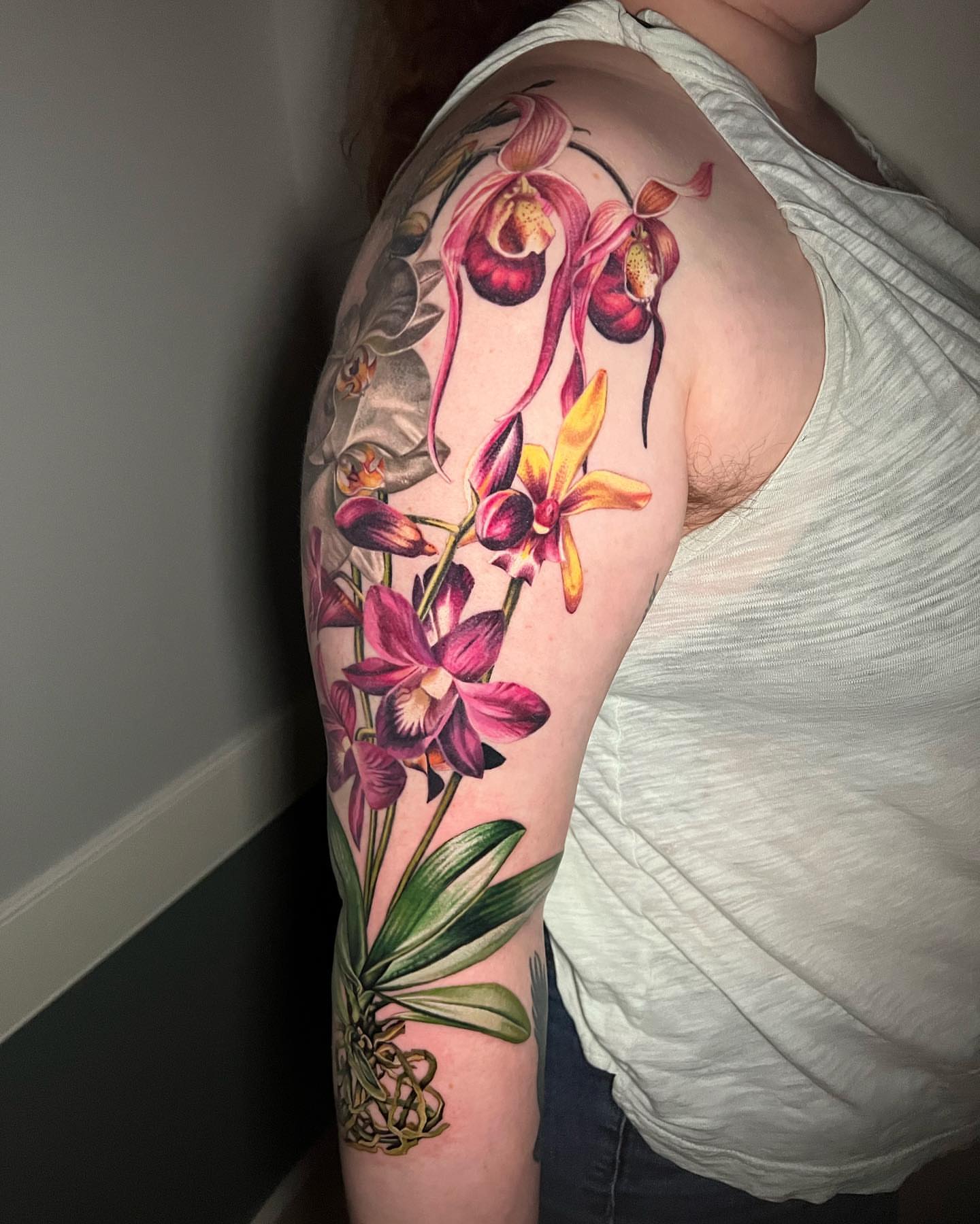 Orchids realism tattoo on the upper arm by Irina Shapiro, Somerville, Massachusetts