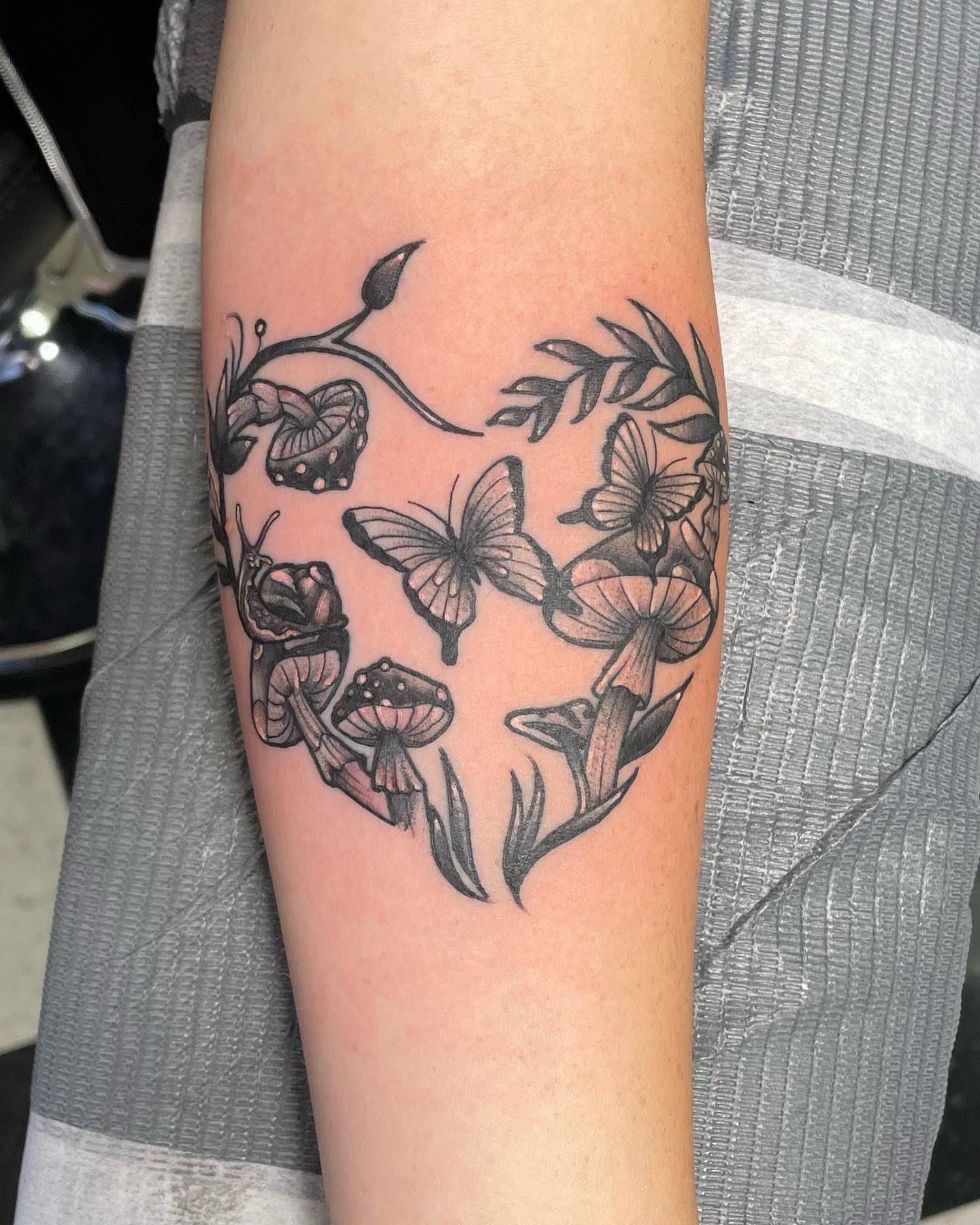 Butterflies and mushrooms black and grey tattoo on the forearm by Don Robison