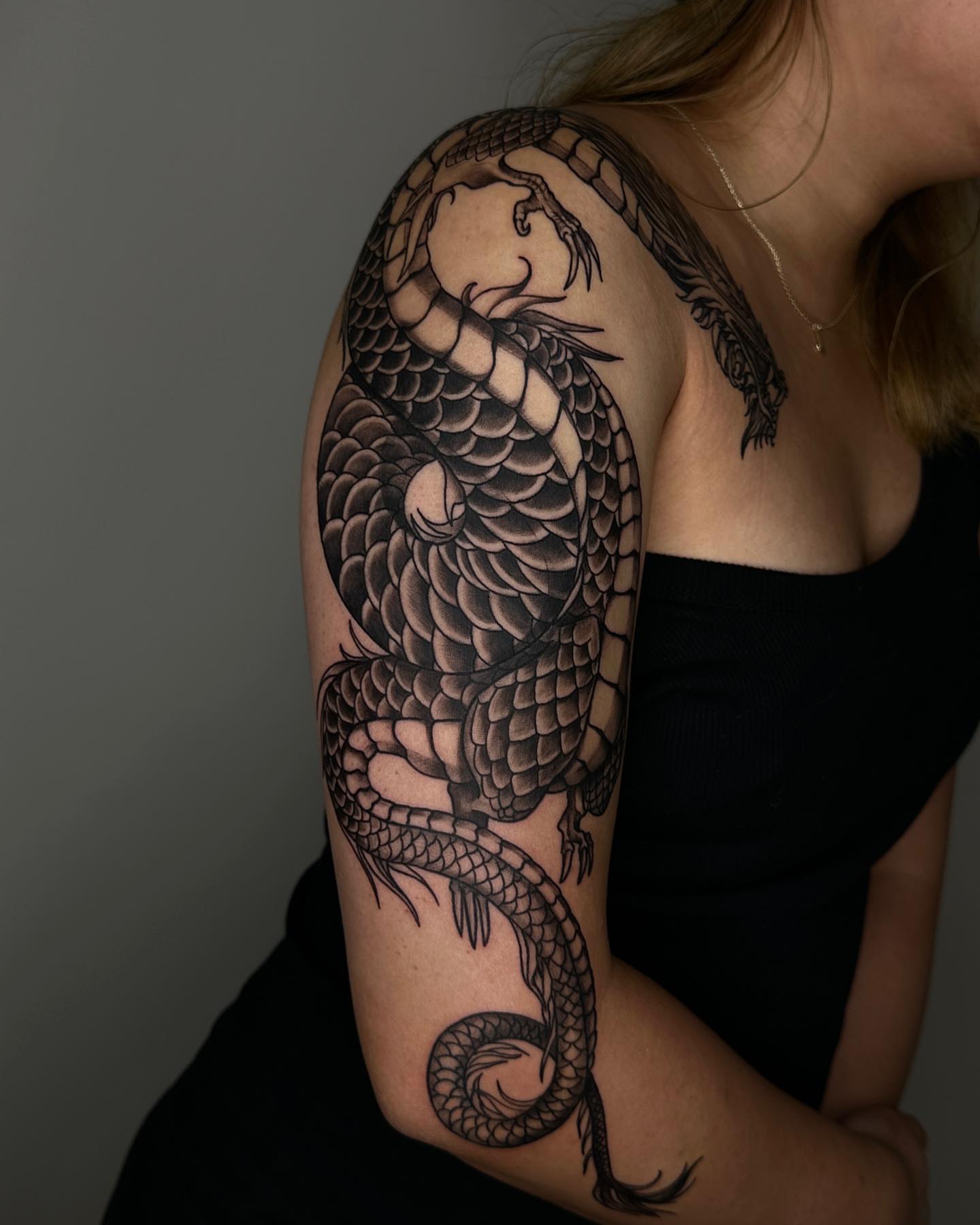 Dragon black and grey tattoo on the upper arm by A L e X