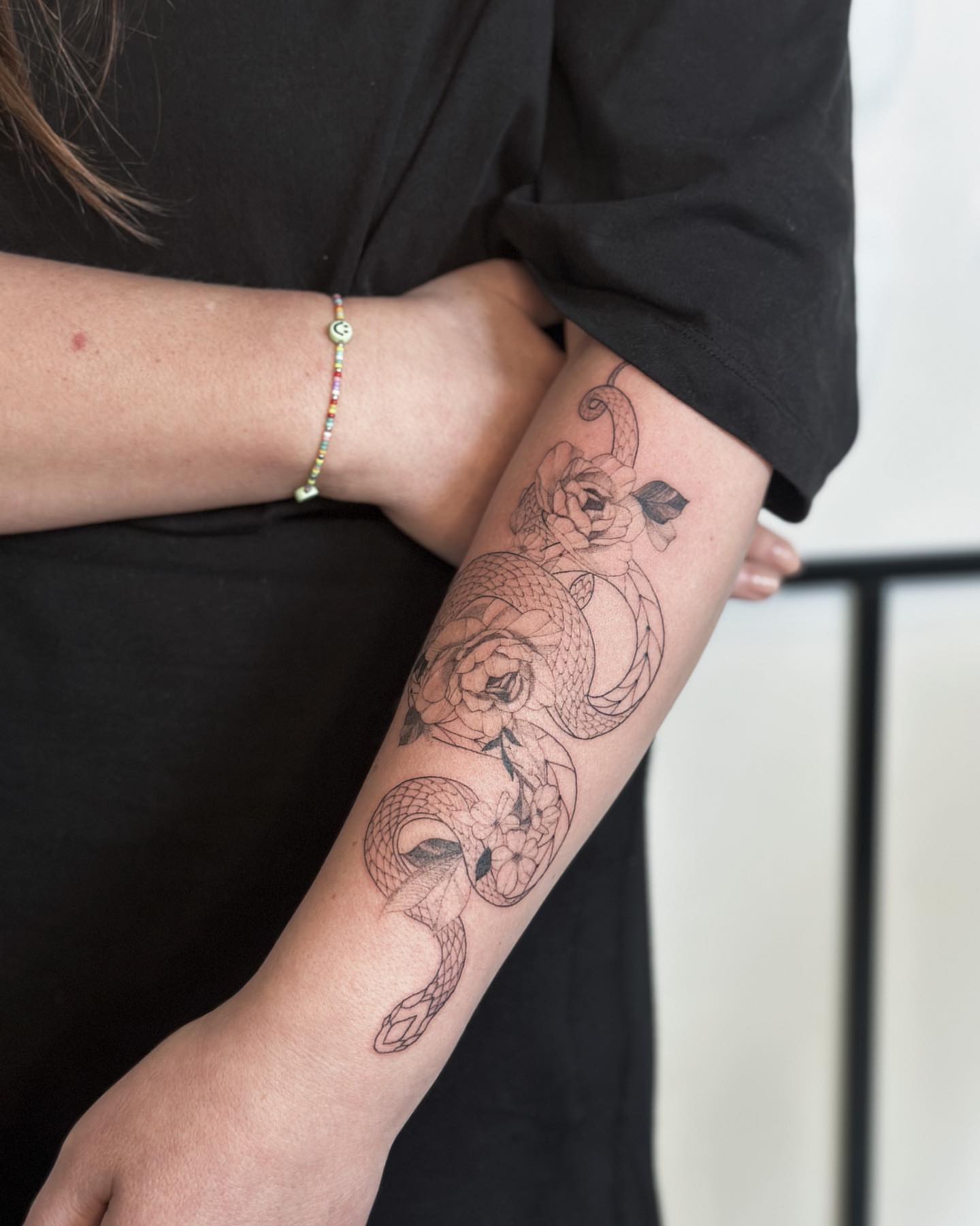 Snake and roses black and grey tattoo on the forearm by Liv
