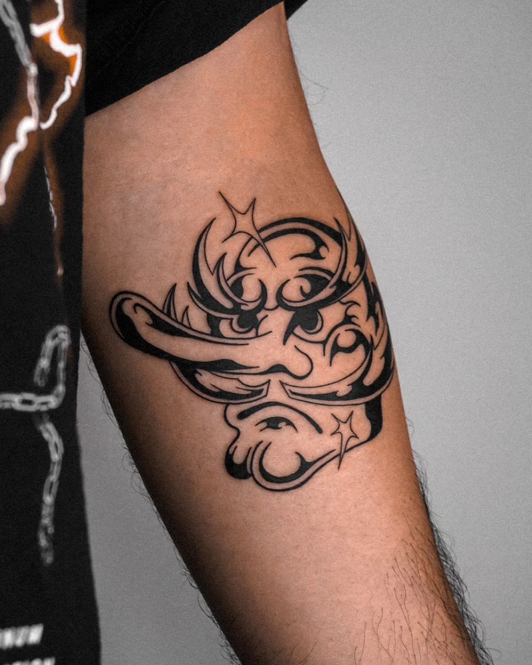 Mask tribal tattoo on the forearm by Jeremy "Jerms" Camposanto