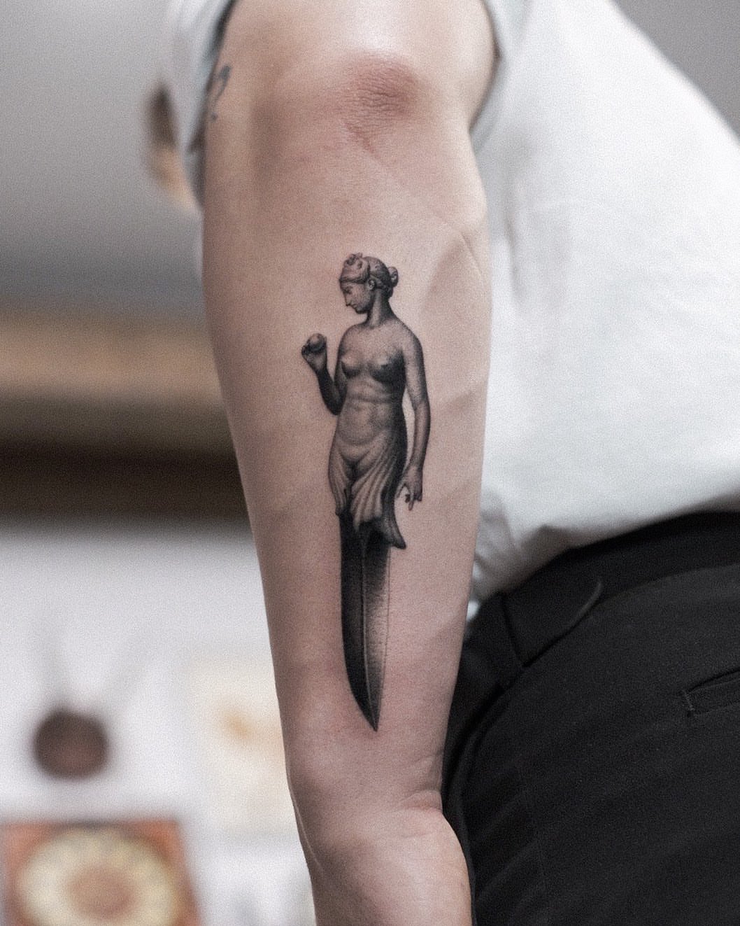 Statue with dagger realism tattoo on the forearm by Oleksandr Moroz
