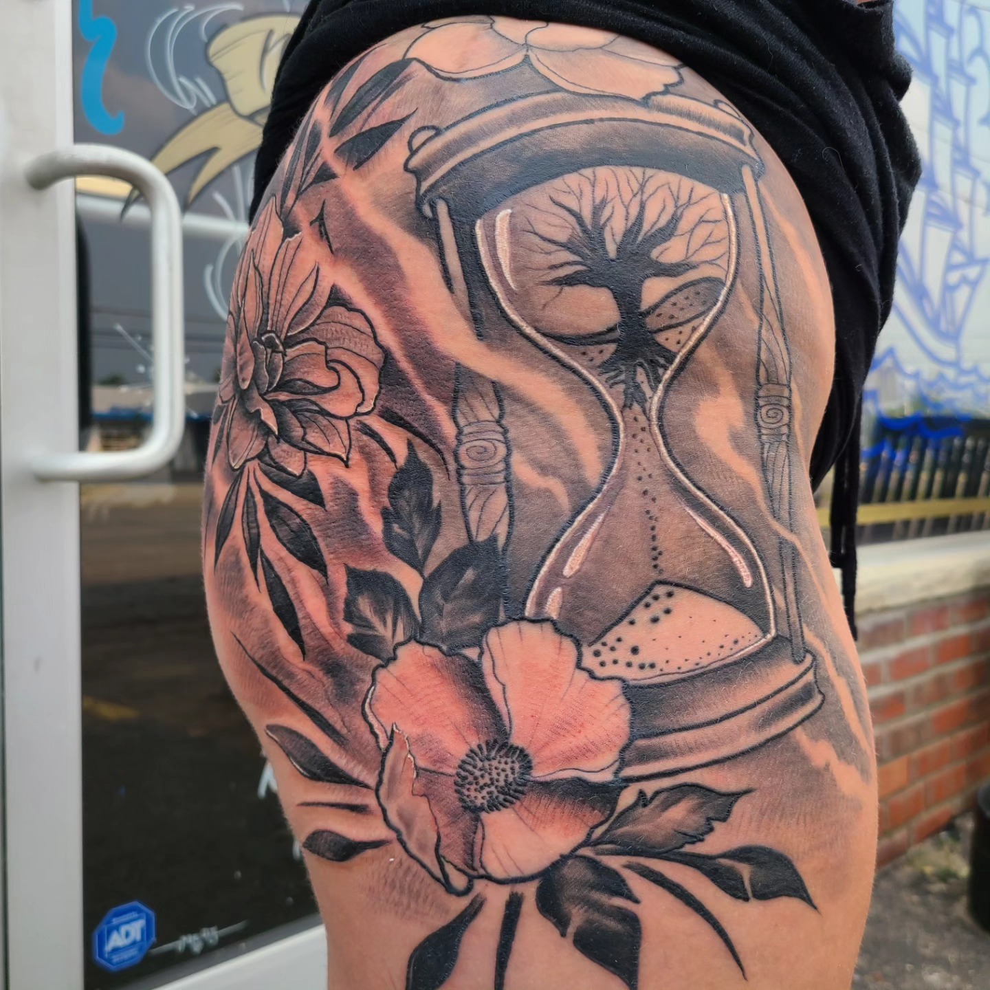 Hourglass and flowers dotwork tattoo on the thigh by David Johnson